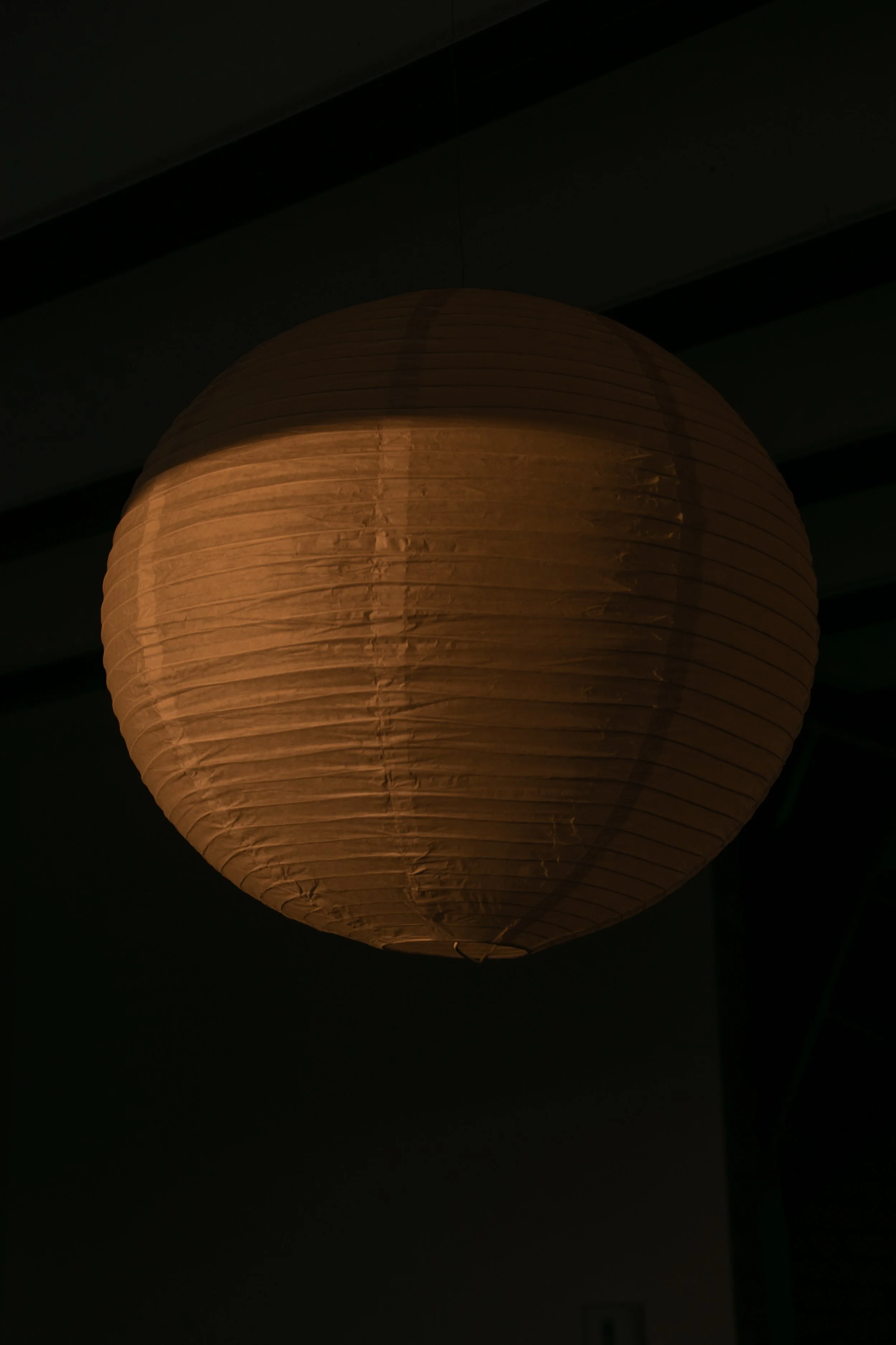Close-up of illuminated paper pendant light with warm ambient lighting