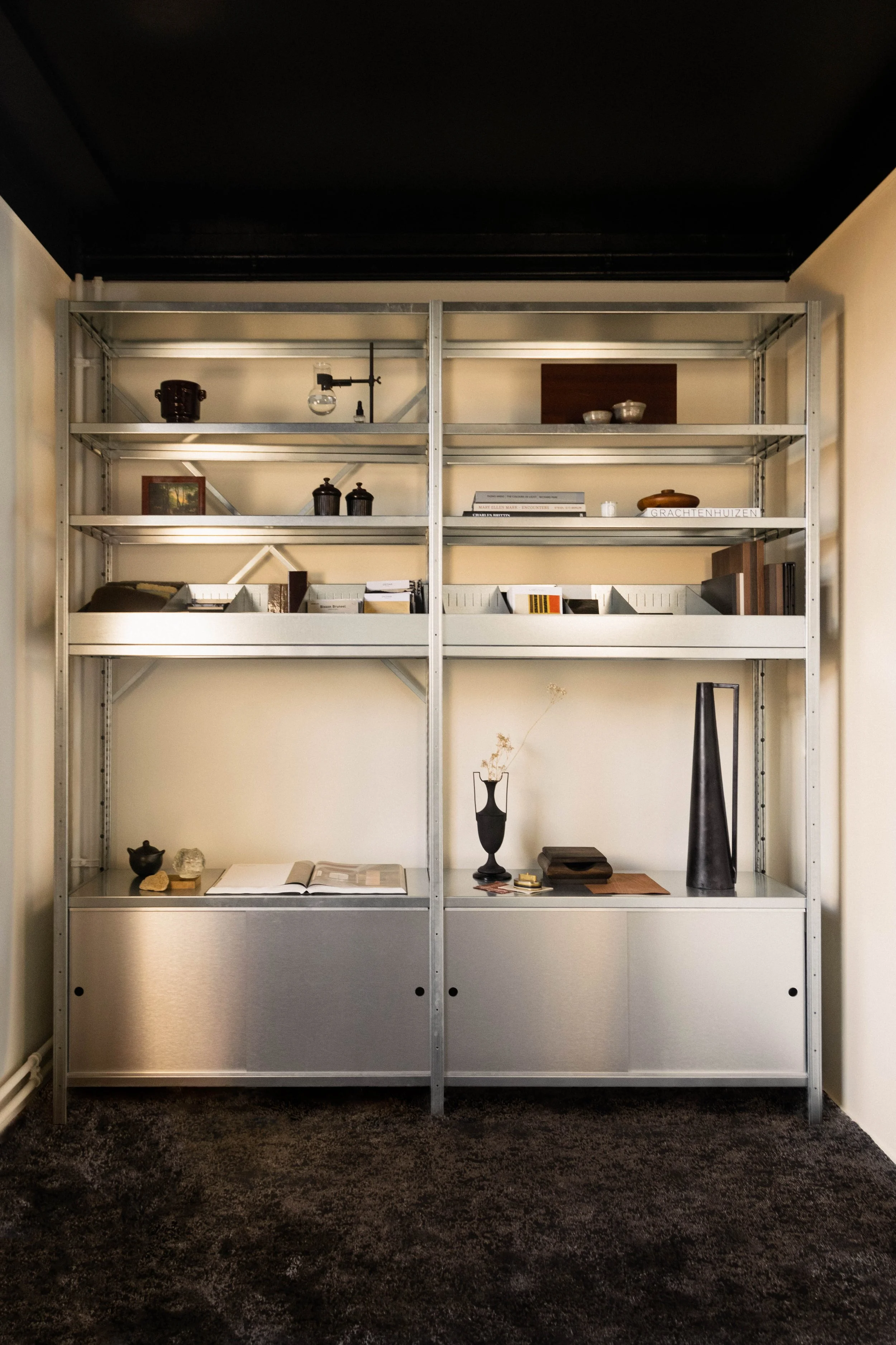 Metal cabinet styled with sculptural objects and books in the Reflections Office, Amsterdam