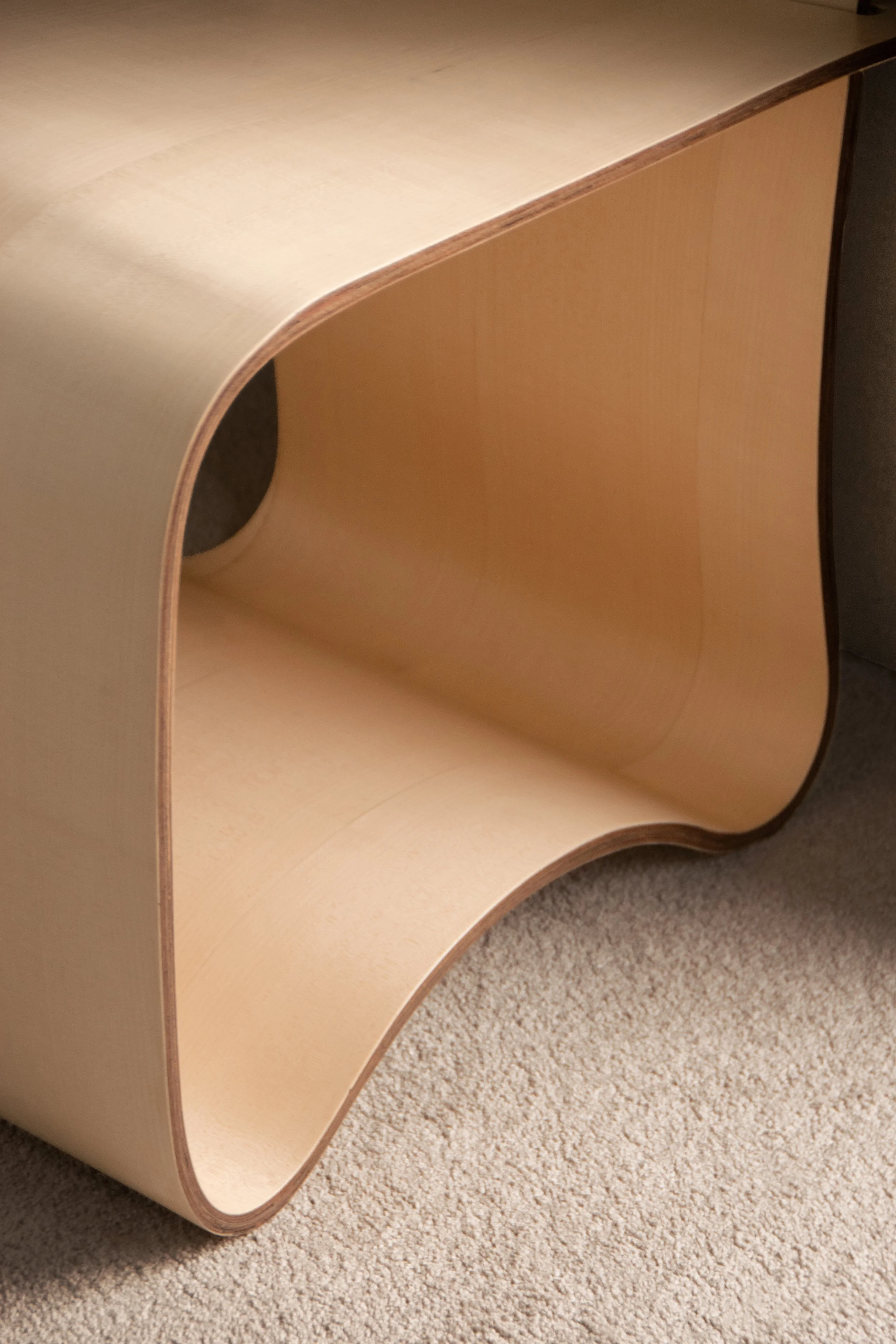 Detail of curved plywood chair with sculptural form