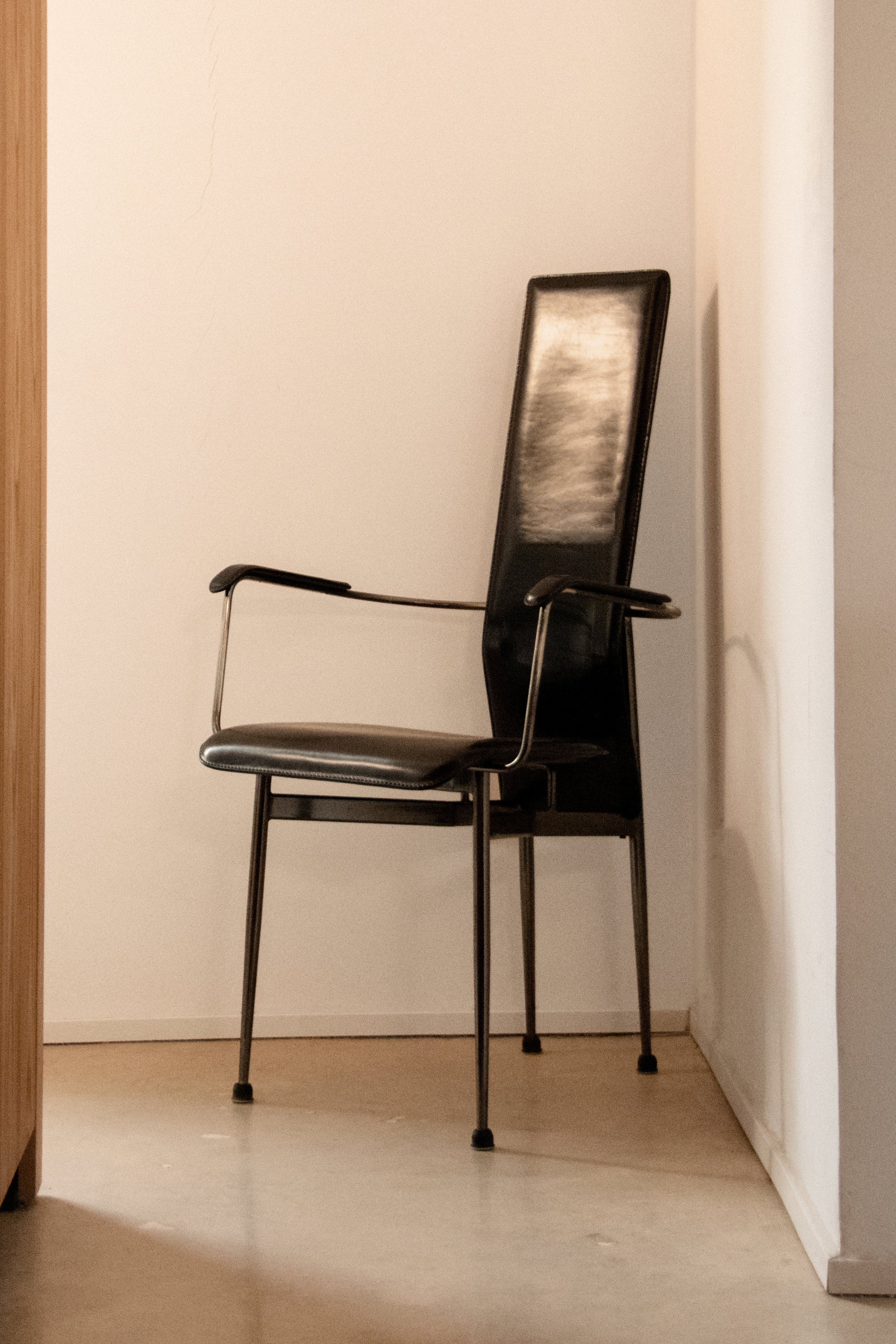 Sculptural black leather chair within calm contemporary interior setting