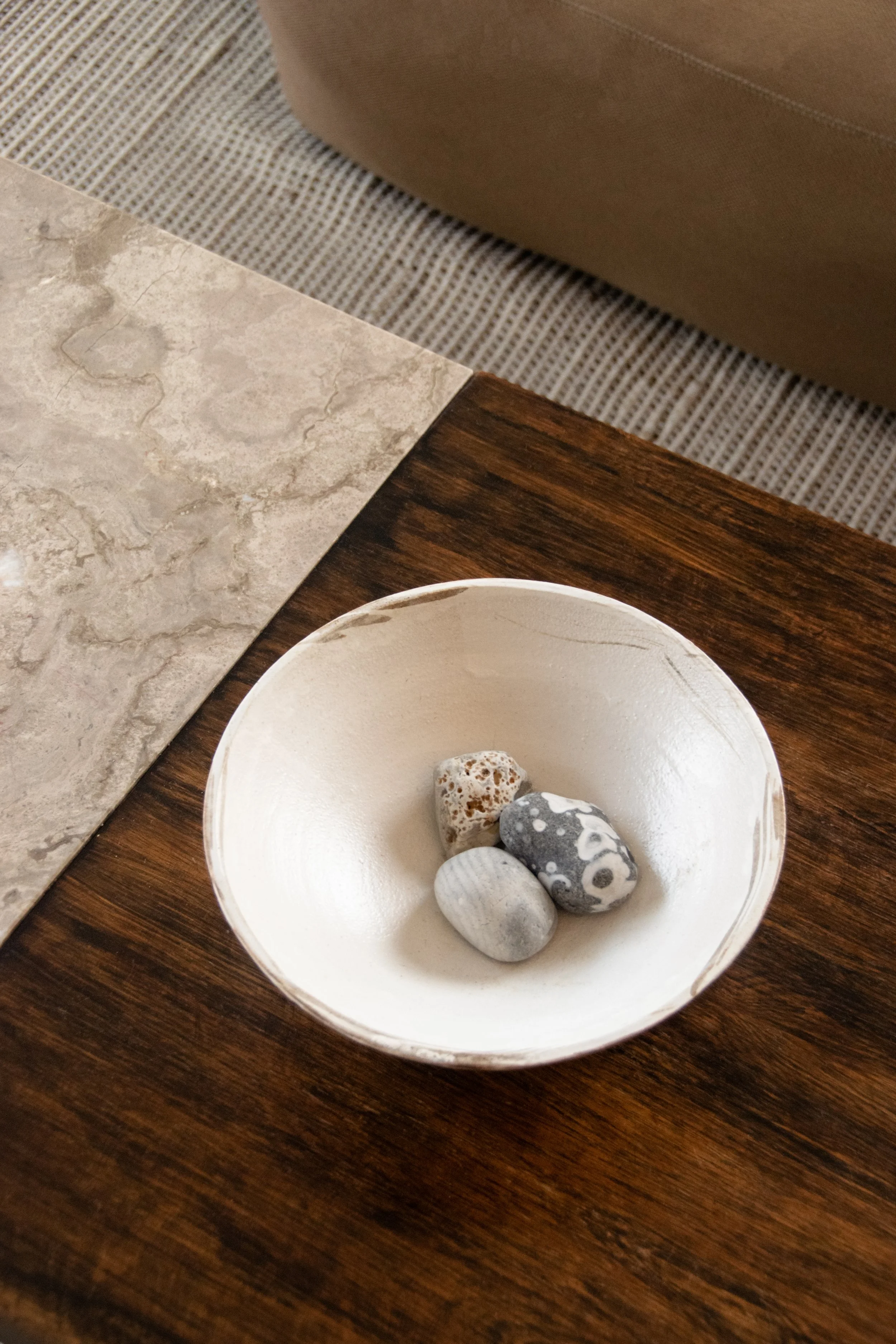Handmade ceramic bowl and natural stone coffee table styling detail