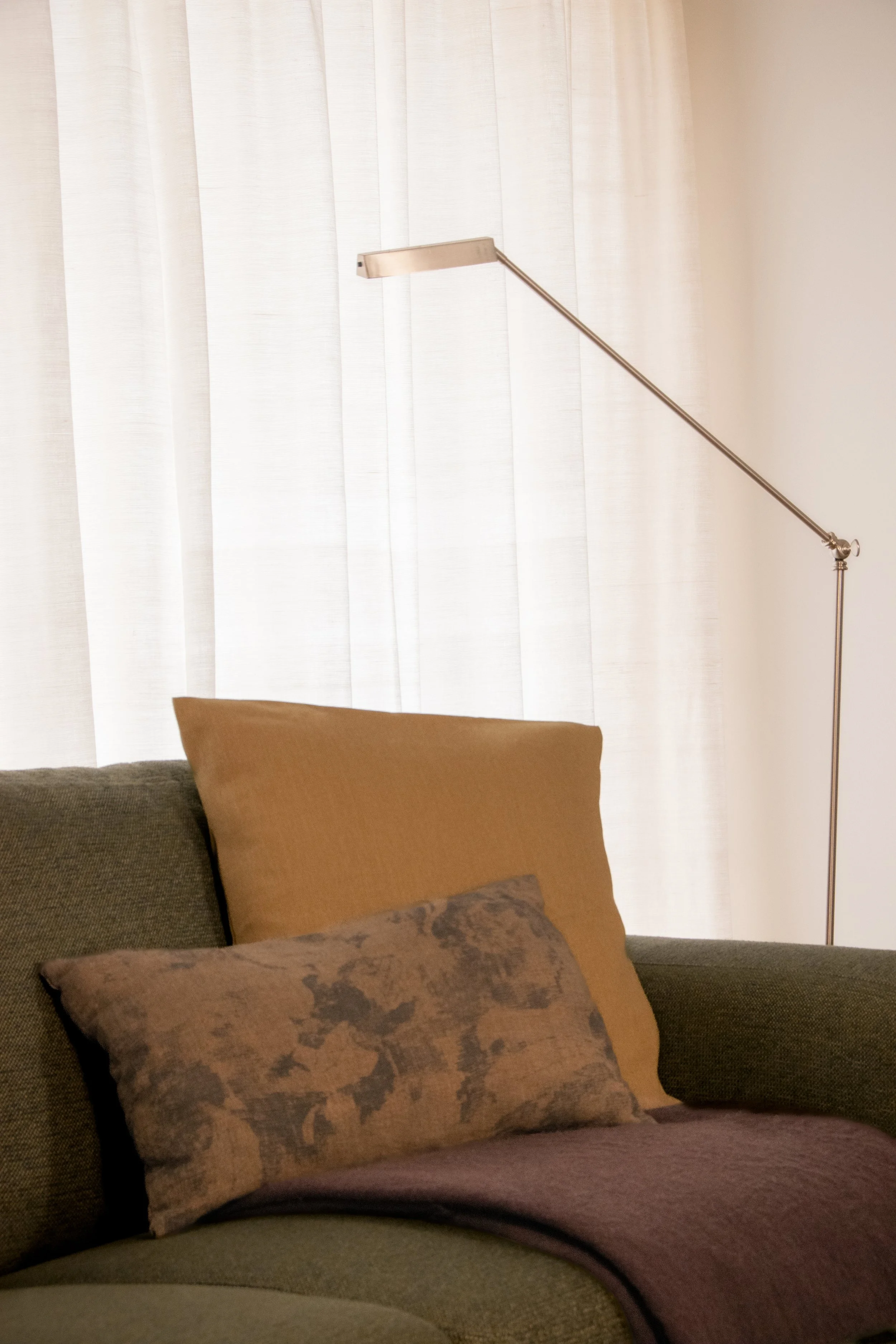 Sofa styling with layered cushions and soft natural lighting