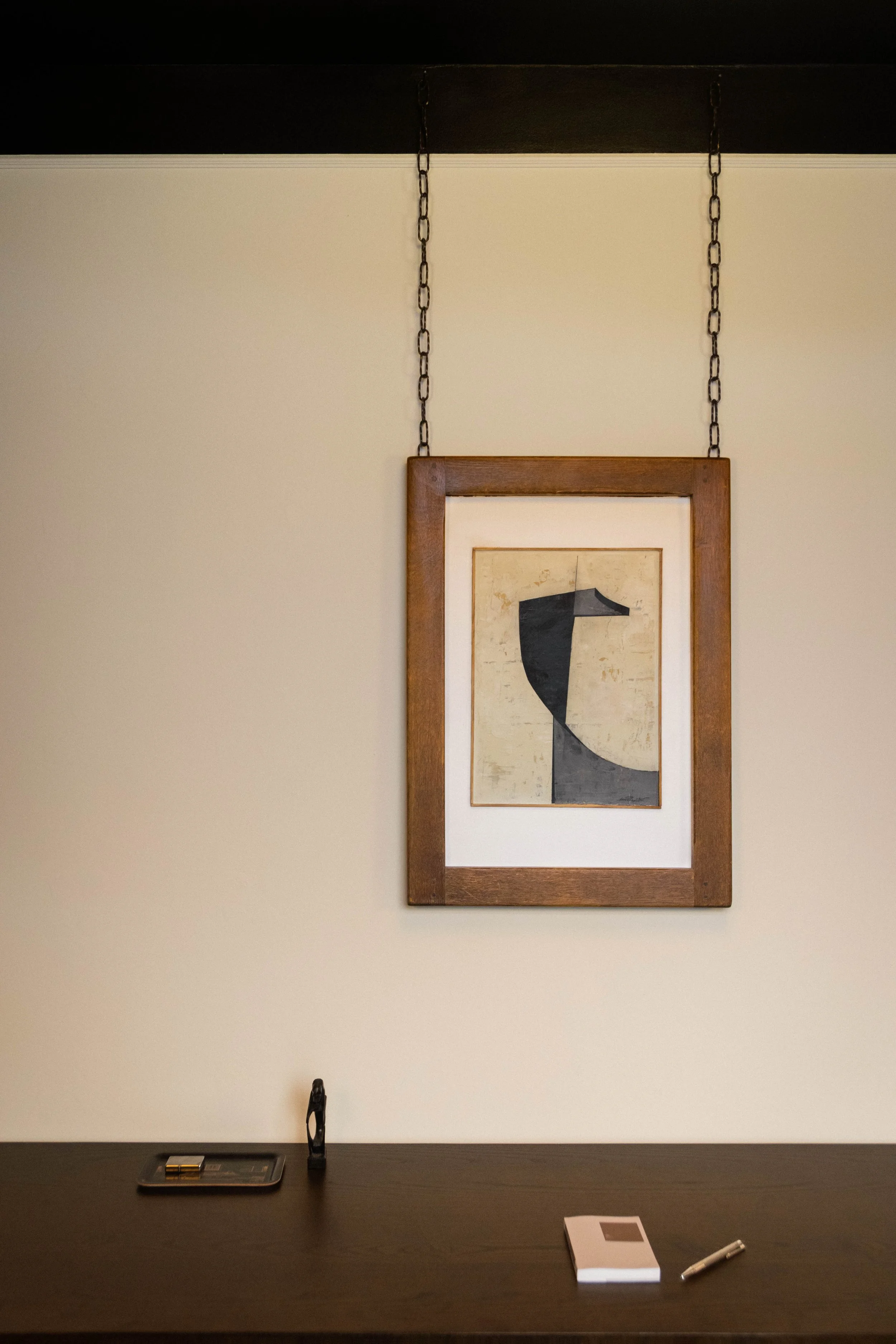 Abstract artwork suspended from the ceiling on metal chains in the Reflections Office