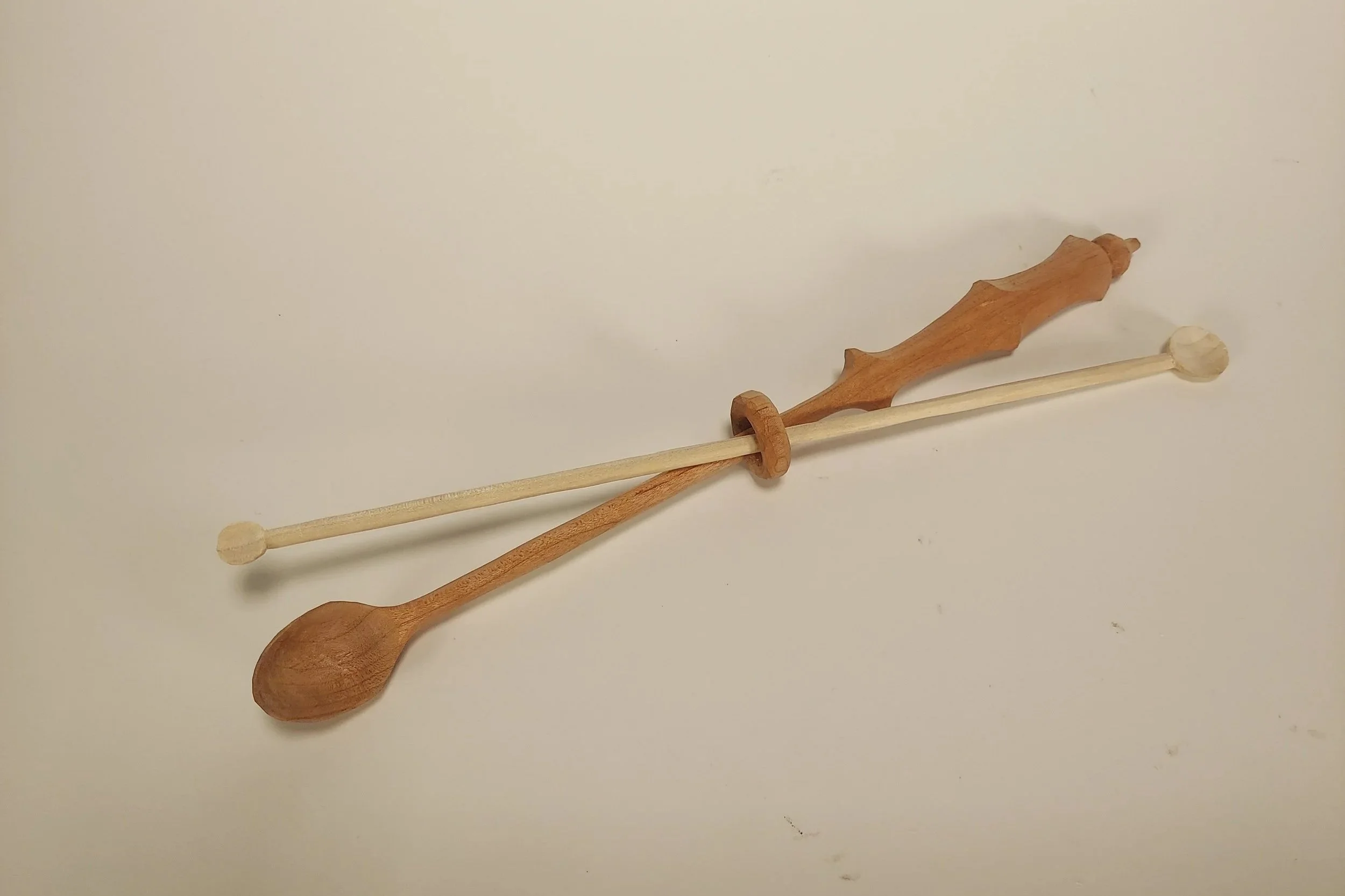 two wooden spoons, one with captive ring