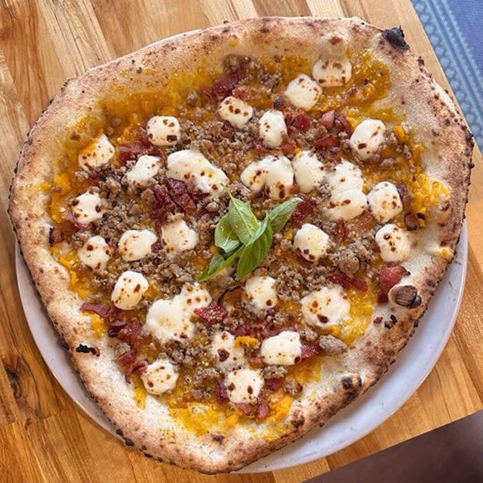 Special Zucca pizza with squash puree, bacon, and truffle sausage