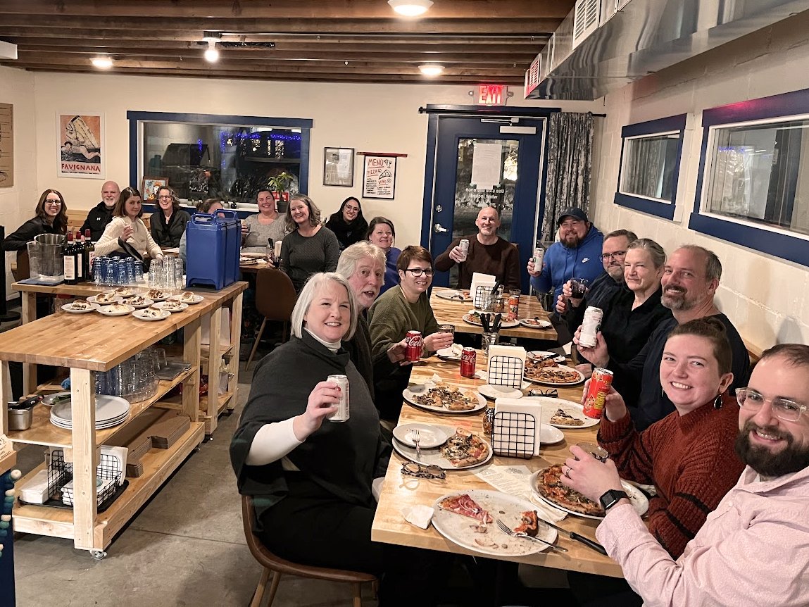 Group of people celebrating together inside pizzeria