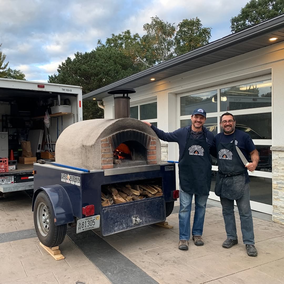 Chris and Alessandro standing in front of their mobile pizza oven