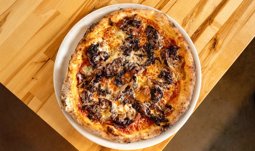 Radicchio pizza special with n'duja sauce, gorgonzola, grilled radicchio, and green onion