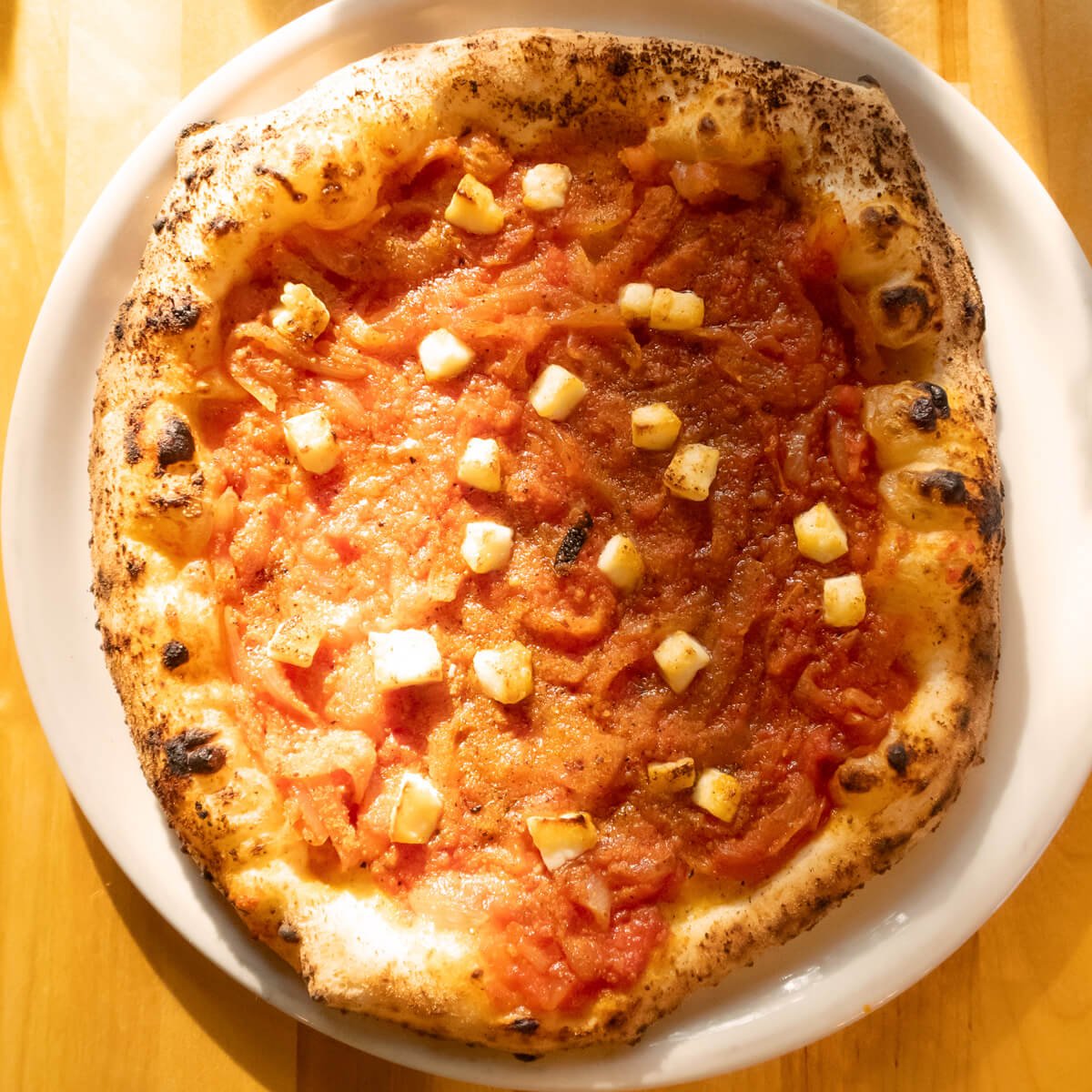 Sfincionello special pizza with onions, tomatoes, and diced pecorino