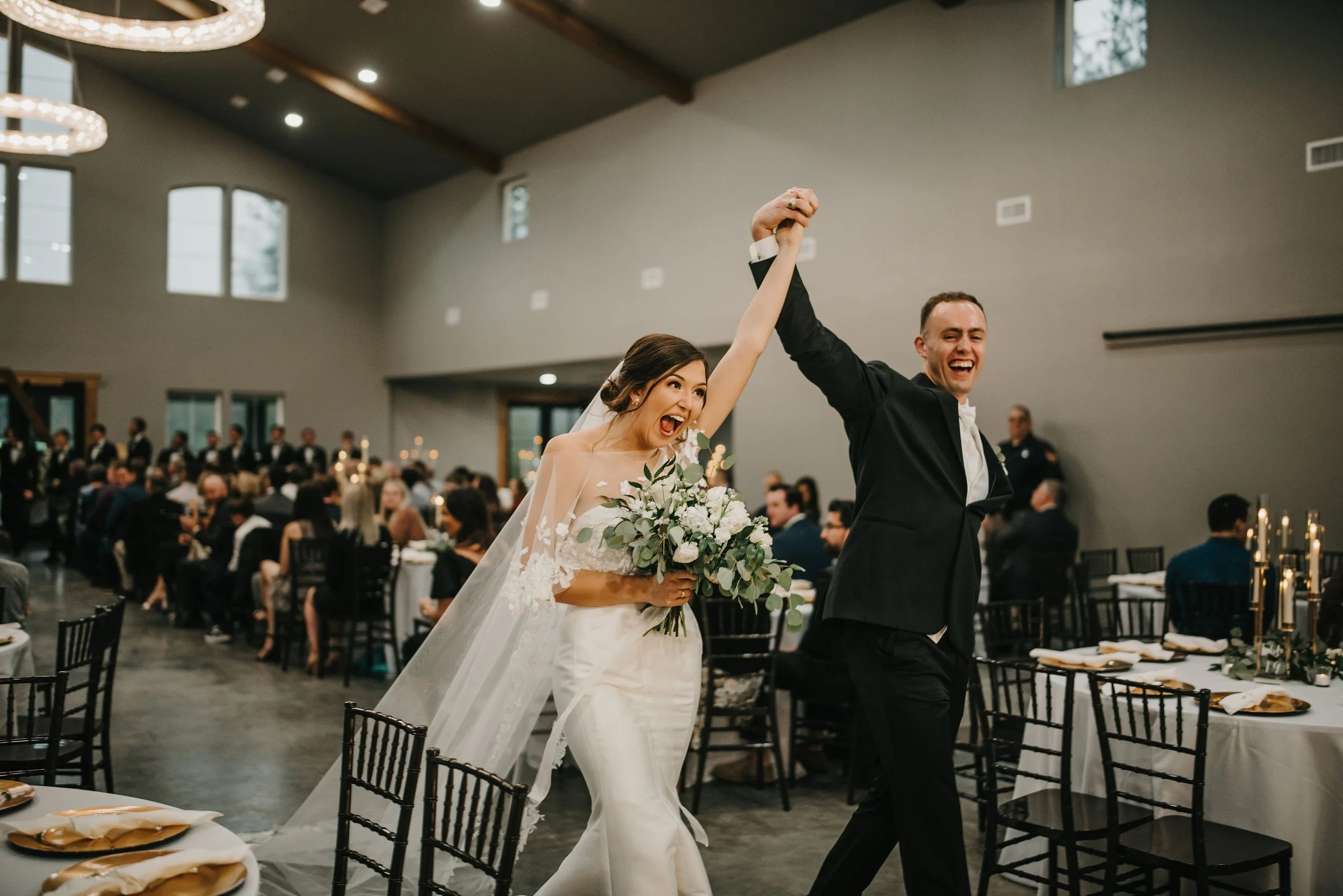 Bride and groom celebrating with raised hands at wedding reception in Beaumont Texas