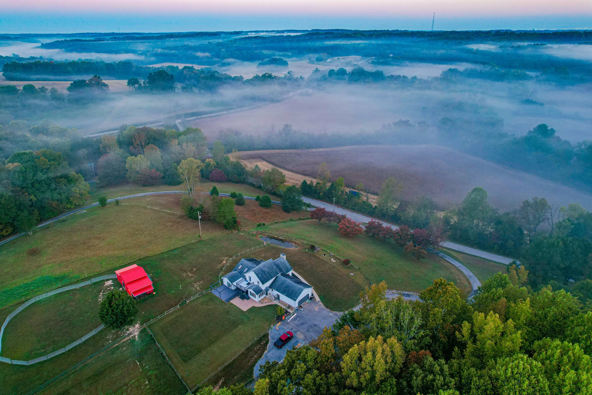 An overhead view of a farm in Tennessee, with fog hanging over the landscape.