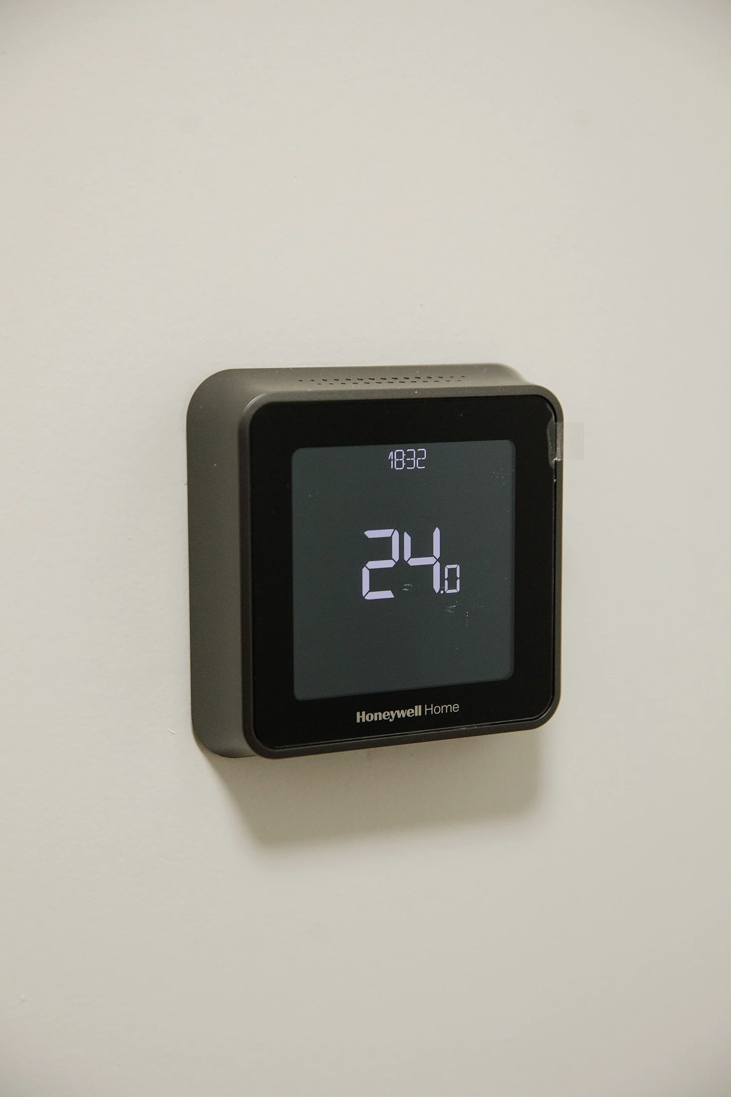 A Honeywell Home digital thermostat mounted on a white wall, displaying a temperature of 24.0 degrees.