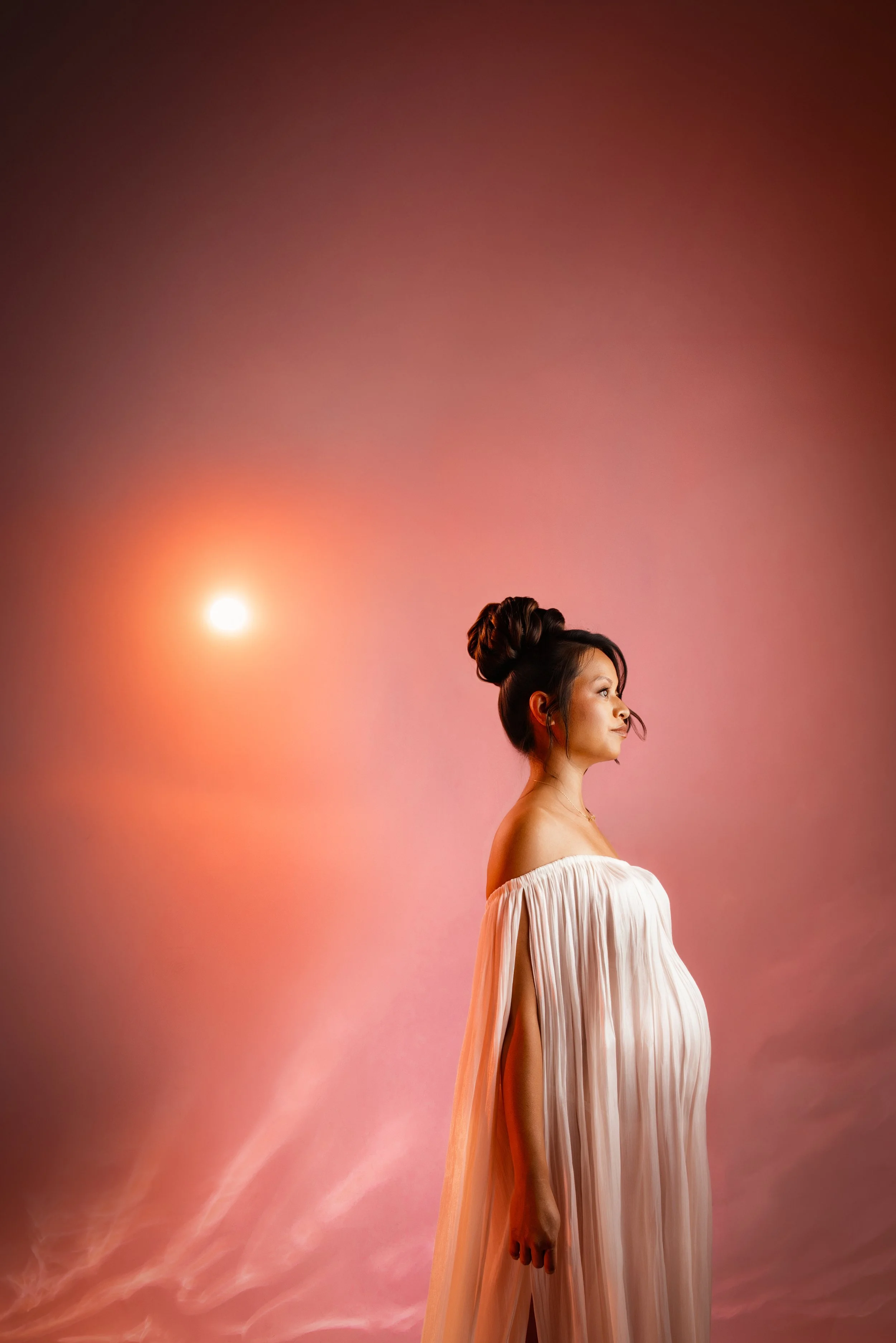 Editorial maternity portrait showcasing dramatic yet elegant lighting and warm tones during a luxury studio maternity session in the Bay Area.