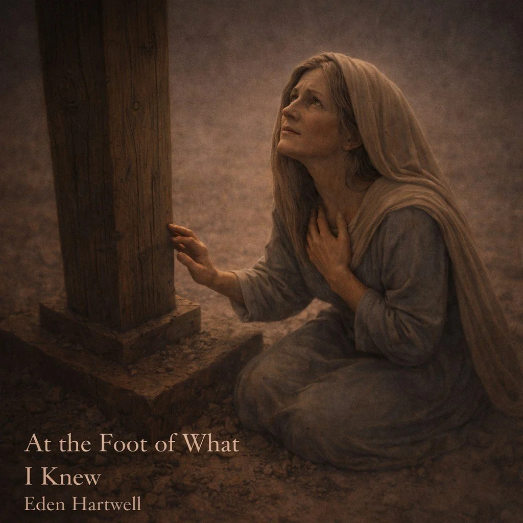 A woman dressed in historical clothing kneels on the ground and looks upward with a distressed expression, touching her chest with one hand and holding onto a wooden post with the other. The scene appears dramatic and emotional, with muted earthy tones. Text in the lower left corner reads: 'At the Foot of What I Knew, Eden Hartwell.'