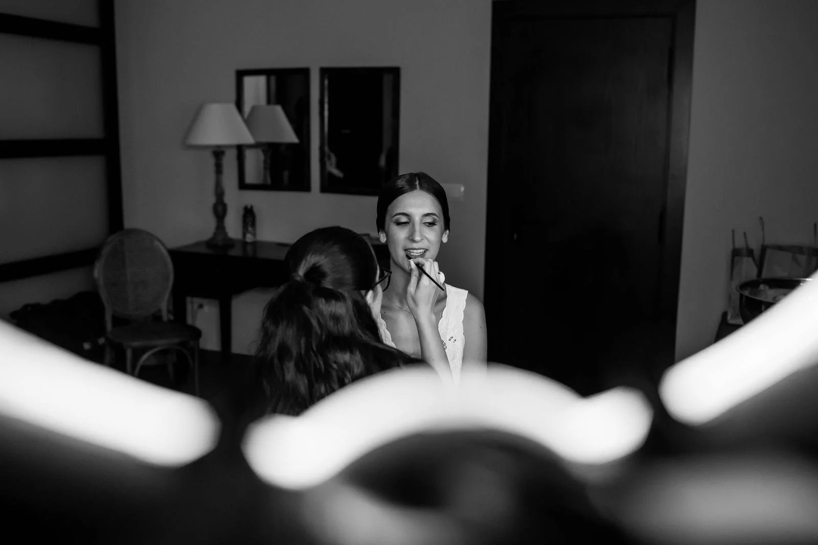 Mujer recibiéndose maquillaje en un entorno interior en blanco y negro