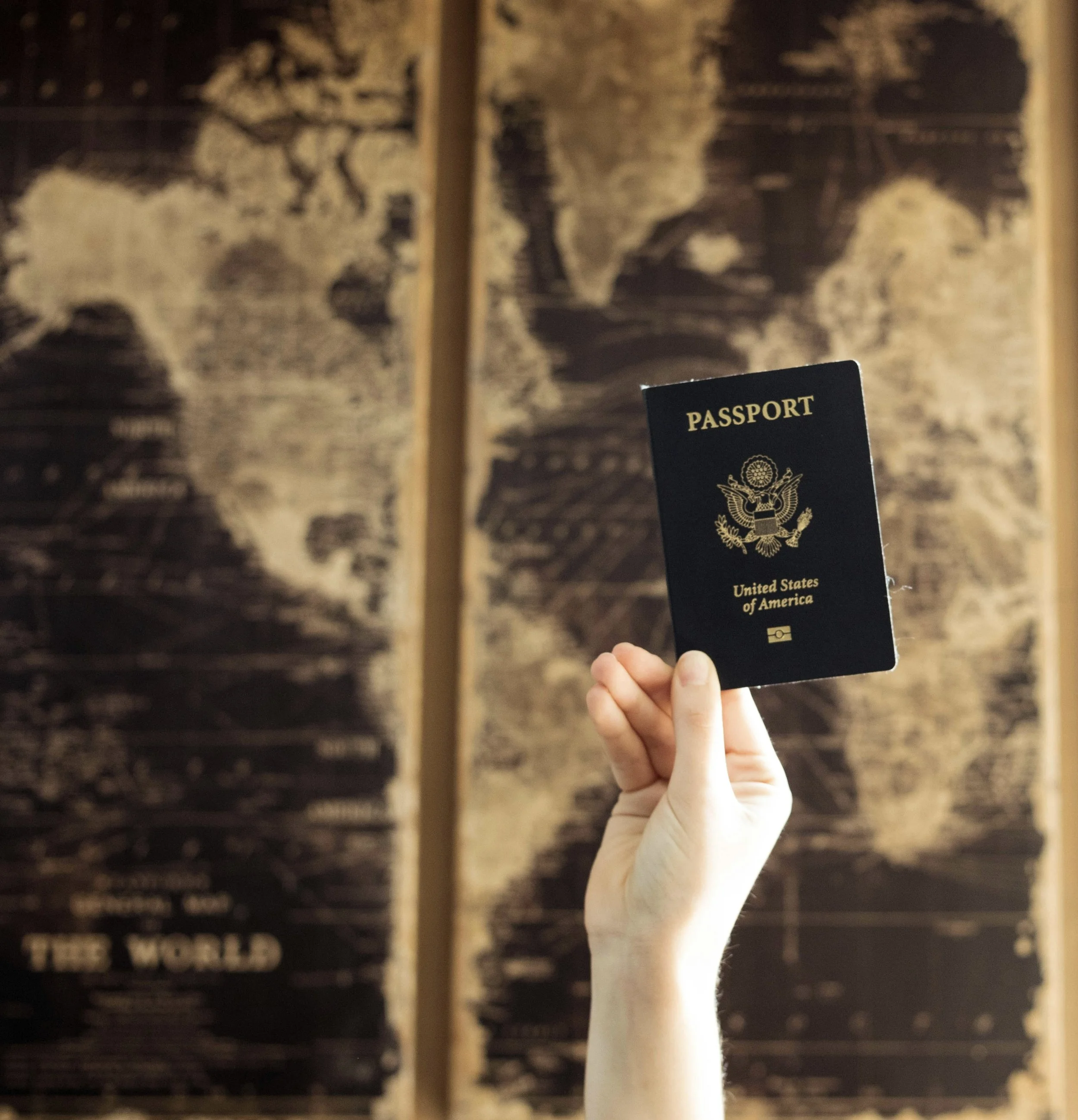 World Map with a person holding a passport in front of it