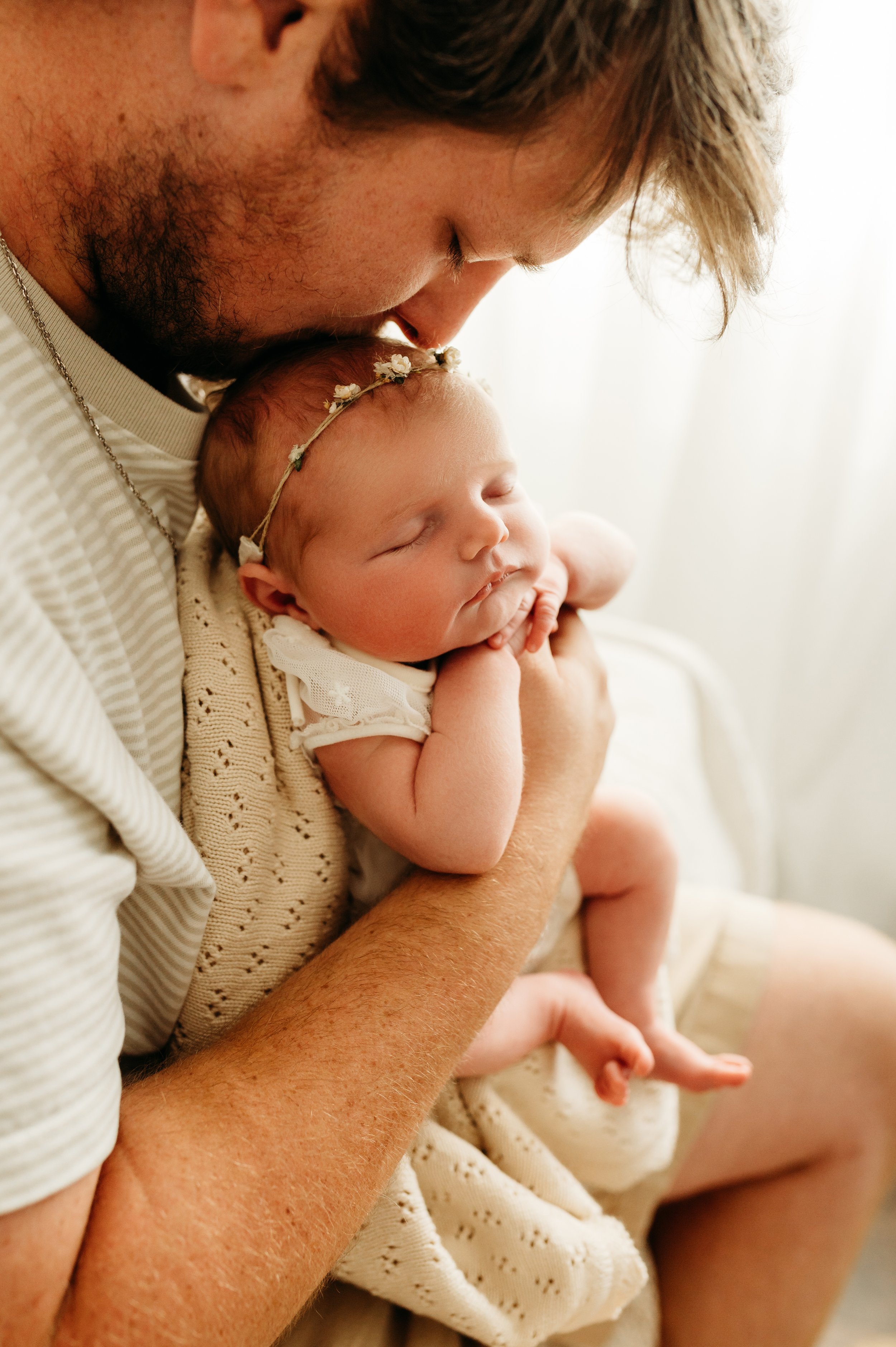 dad kissing newborn baby girl in Ashland City, TN photography studio