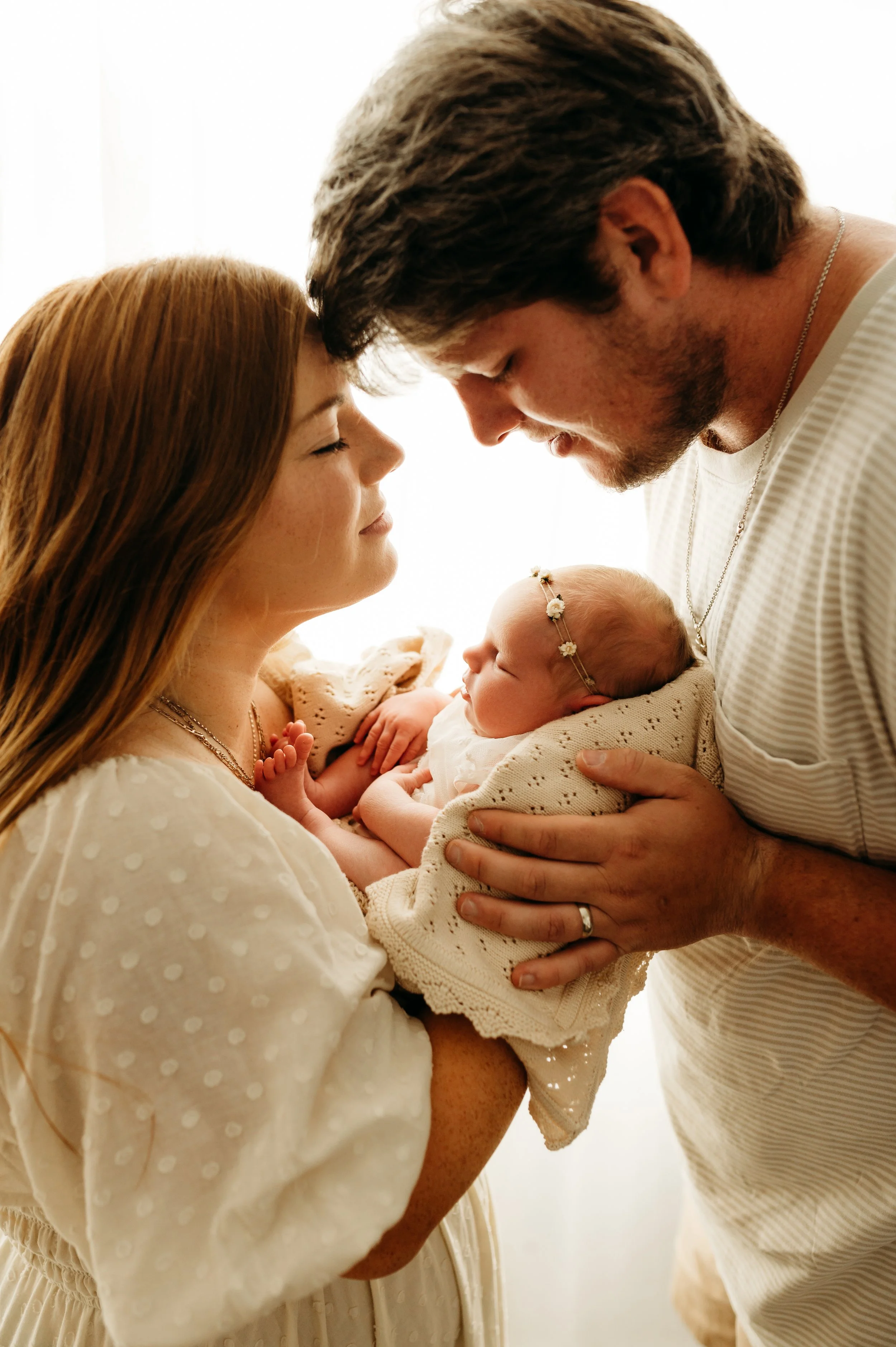 mom and dad in simple white newborn session with baby girl in Nashville, TN