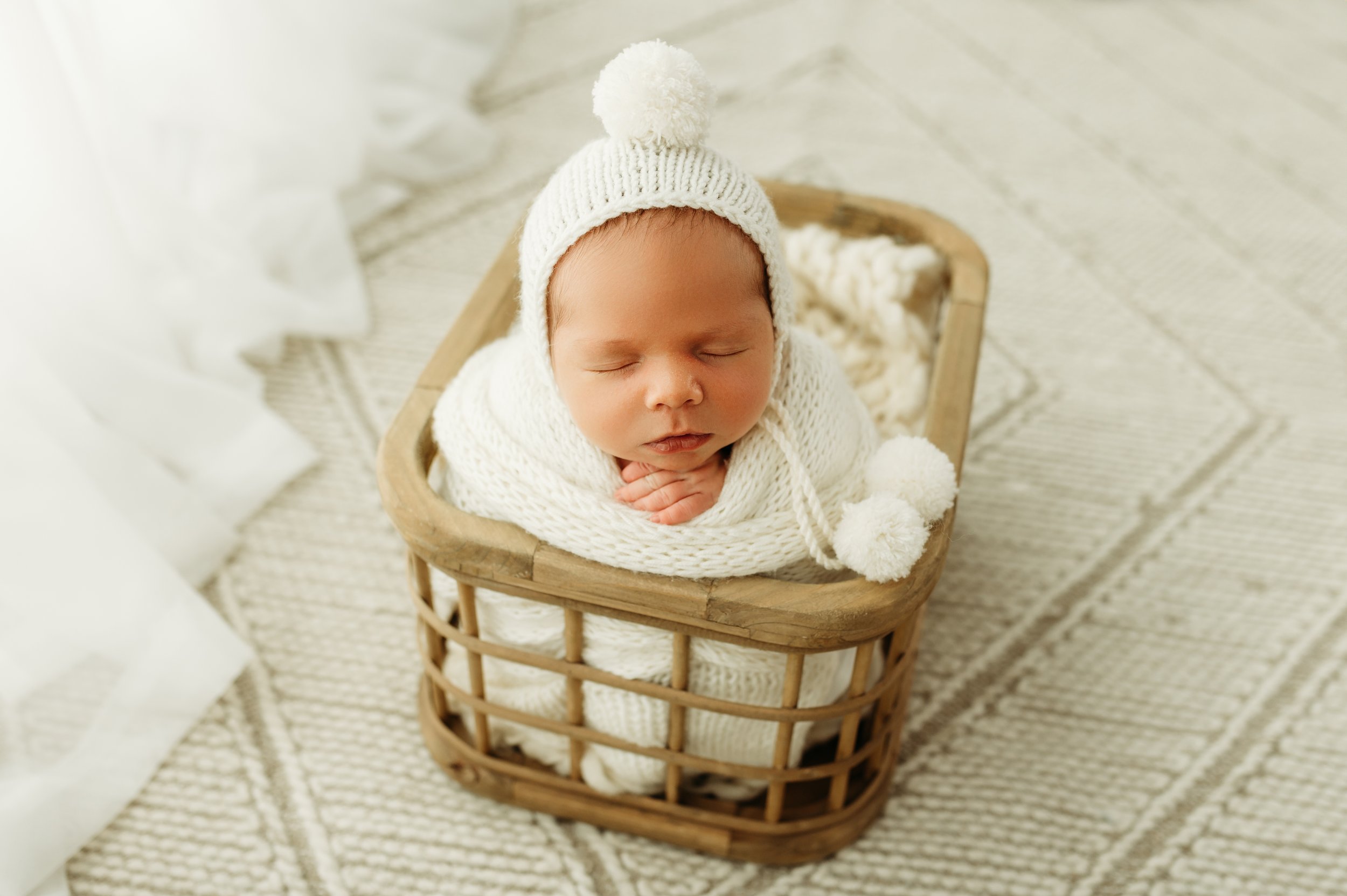 newborn baby boy in a basket with a bonett photograph by a nashville, tn newborn photographer
