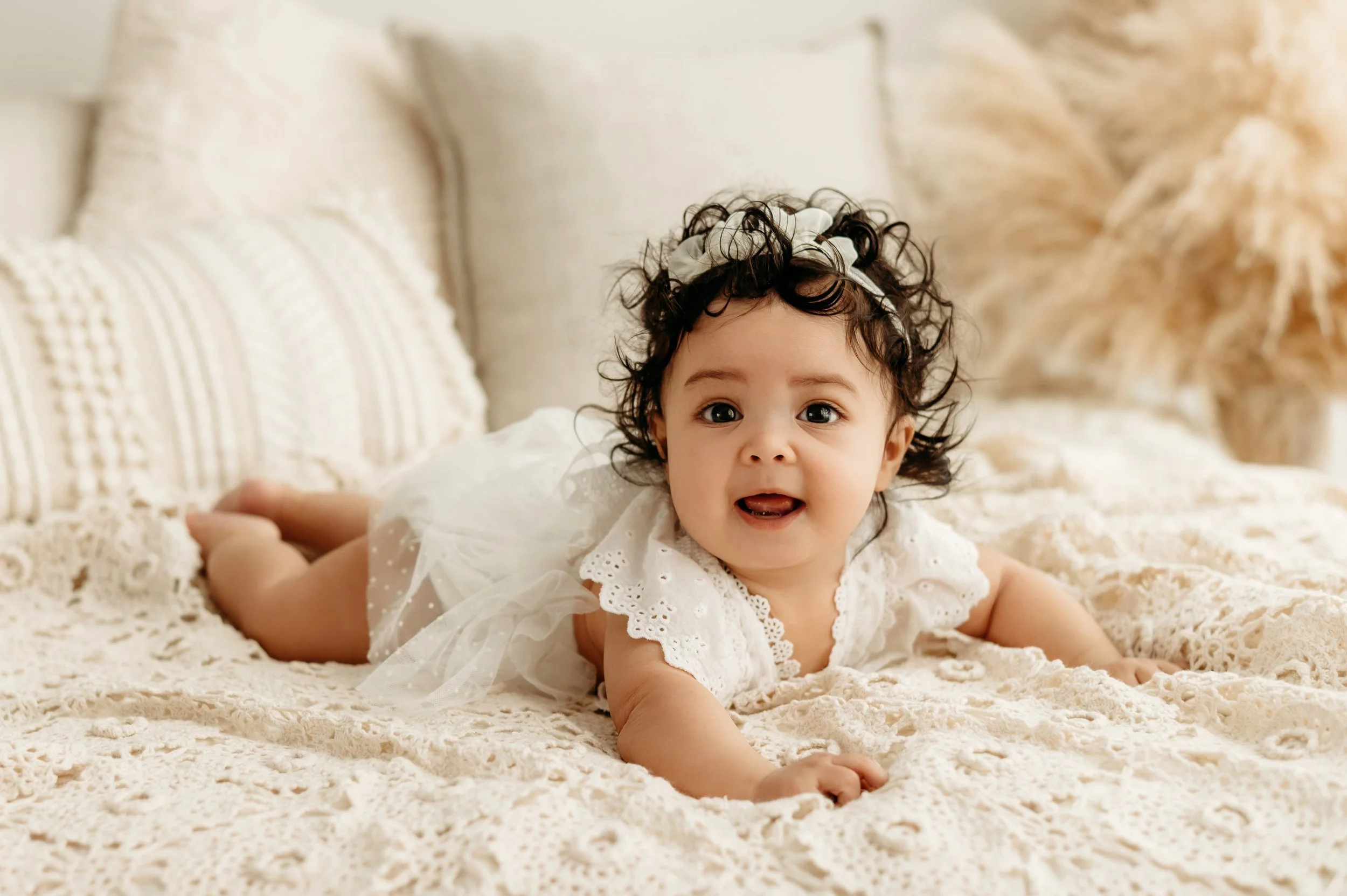 baby girl in a nashville, tn studio for her baby photos wearing an outfit from the client closet along with a precious headband