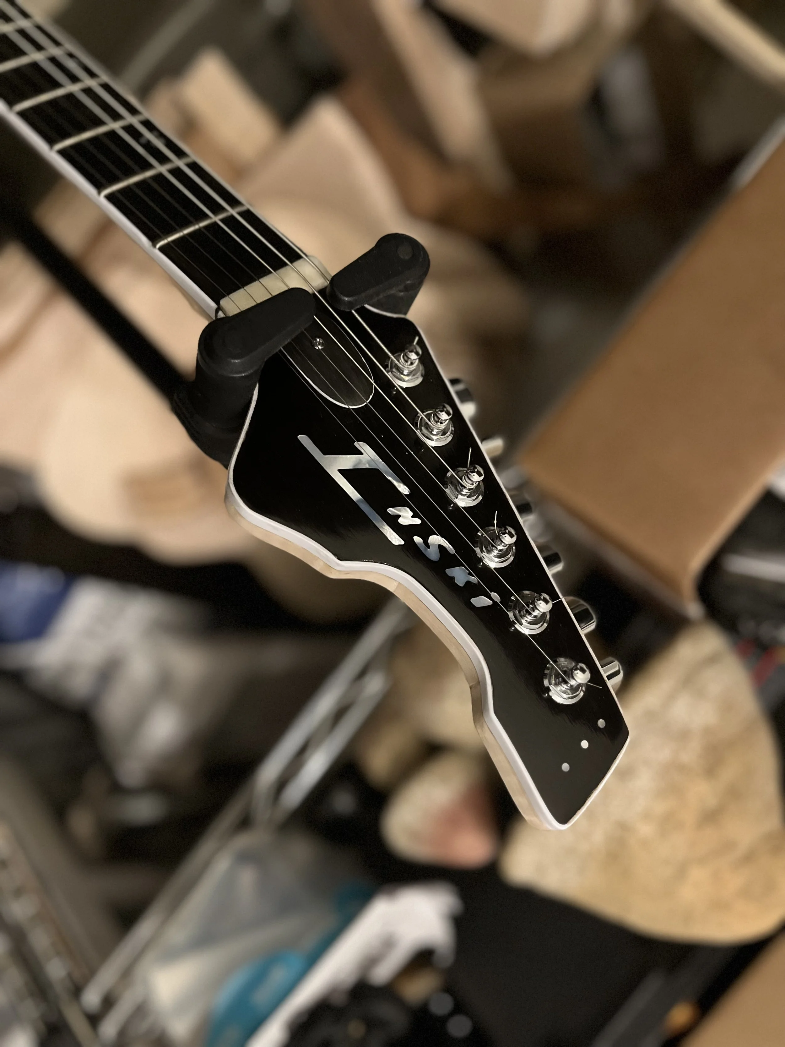 Close-up of an electric guitar's headstock showing tuning pegs and part of the neck with strings.