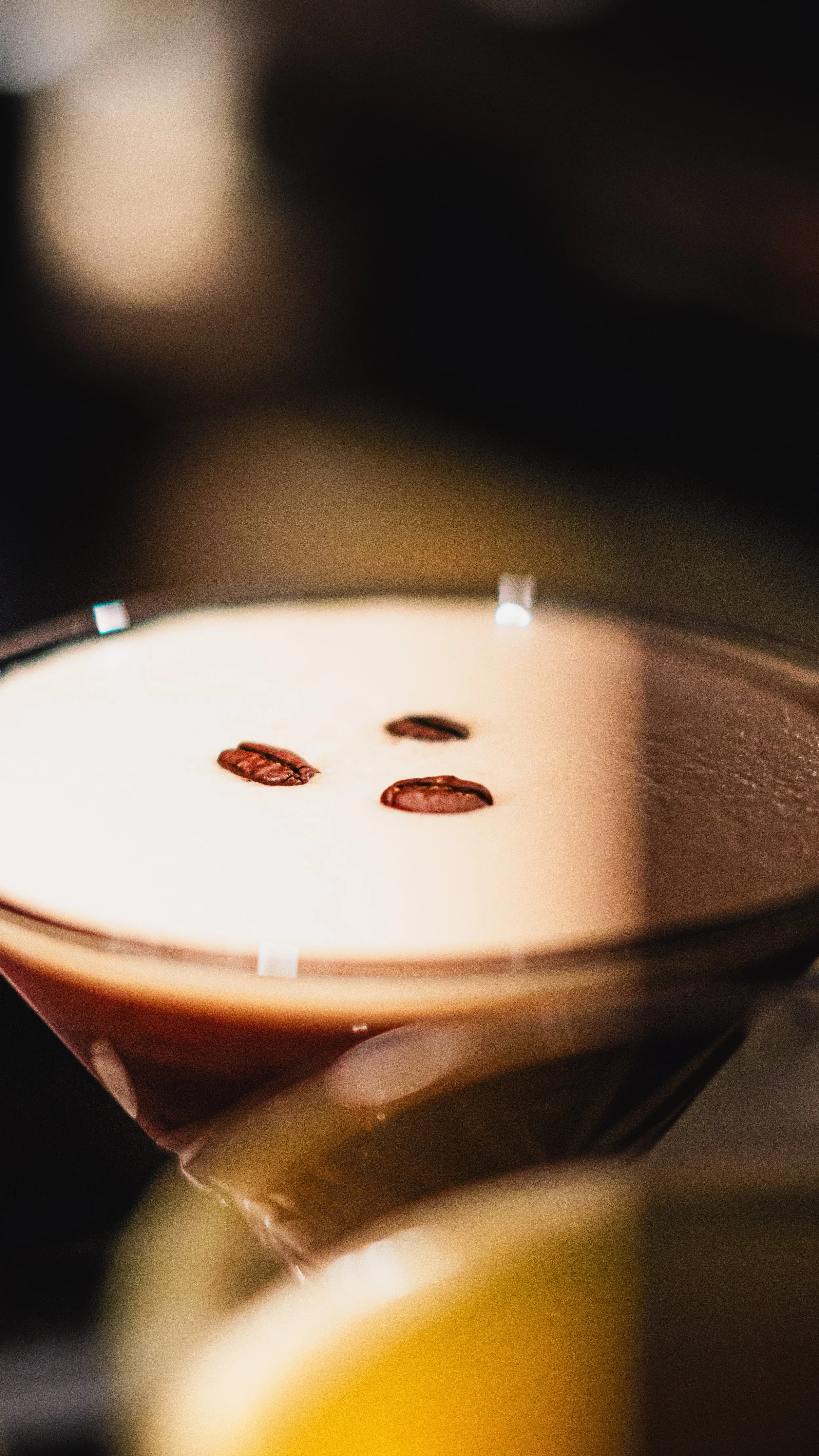Tasse de café cappuccino avec trois grains de café en haut, vue de dessus, avec une surface mousseuse