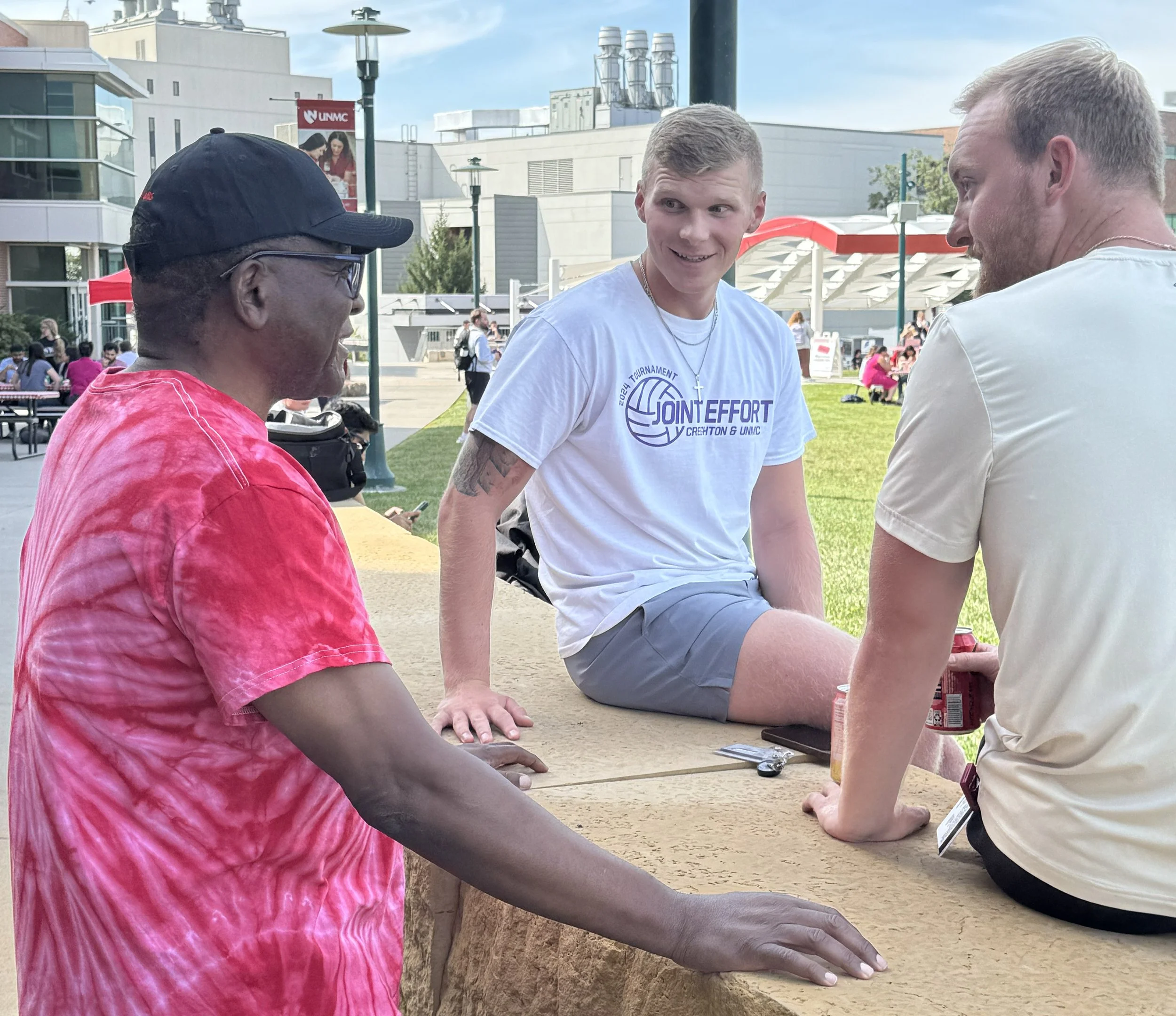 Dr. Dele Davies talks to two students at a picnic