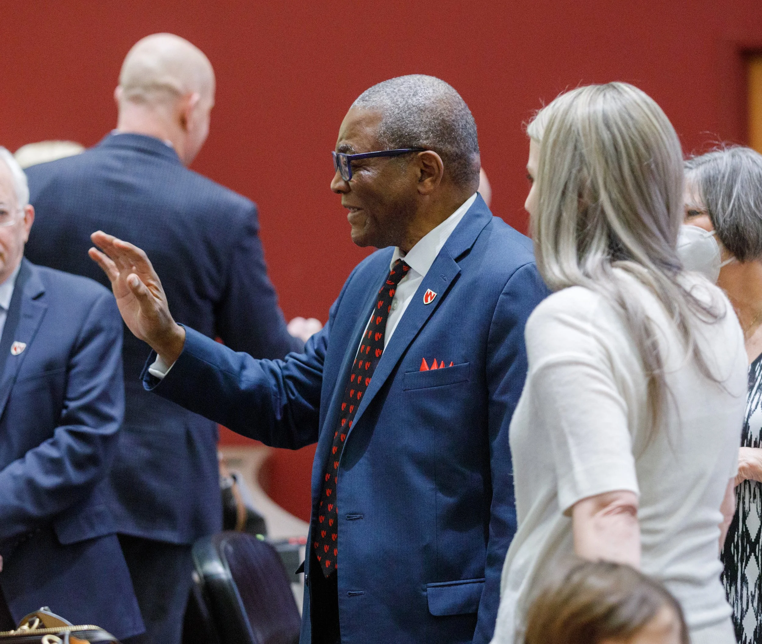 Dr. Dele Davies waves to someone in a crowd