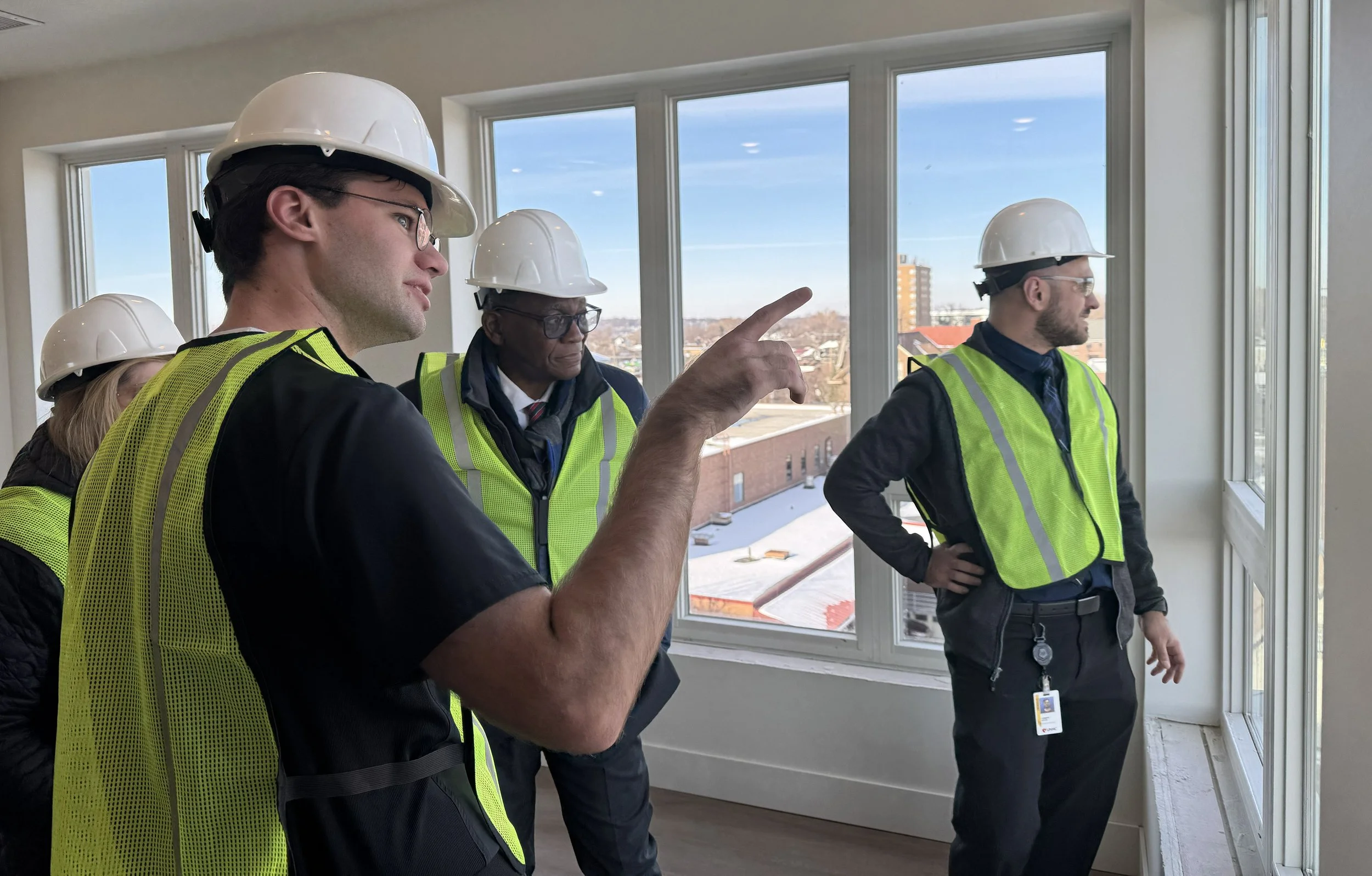 Dr. Dele Davies and students look out window of new building