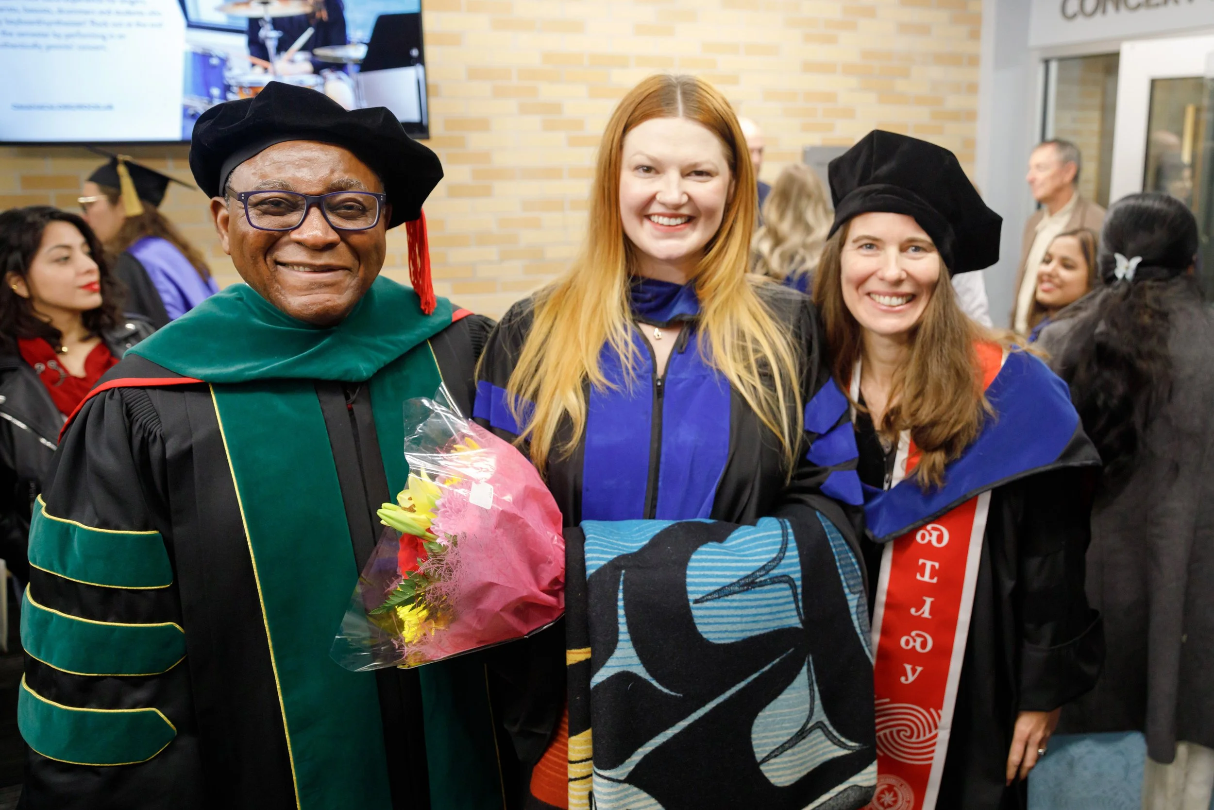 Dr. Dele Davies poses with student and mentor at graduation