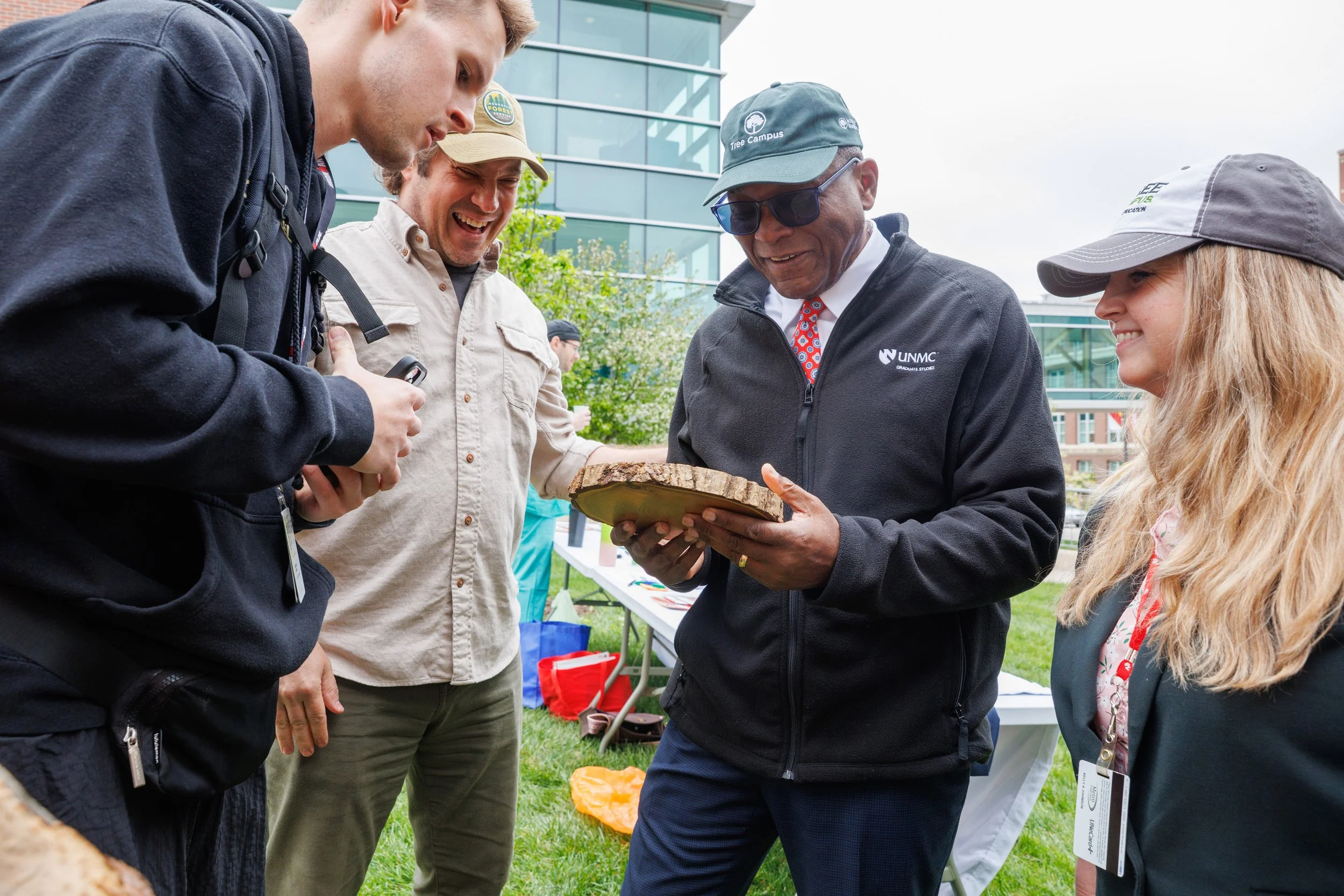 Dr. Dele Davies looks at rings in tree trunk with students