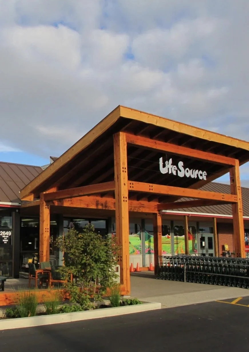 Entrance of a store named LifeSource with a wooden framing structure and shopping carts outside.