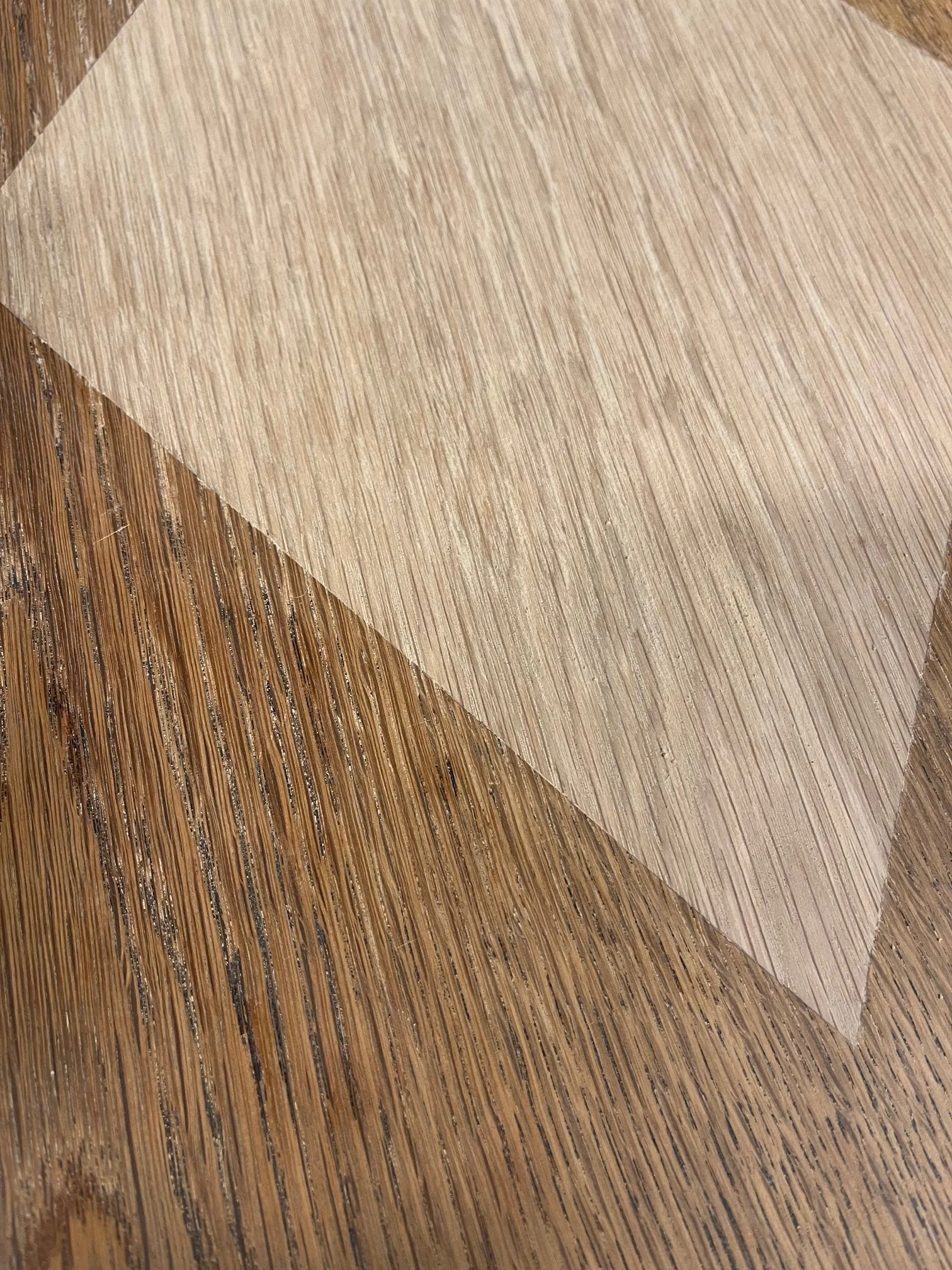 Close-up of two textured wooden surfaces, one darker and one lighter, overlapping at an angle.