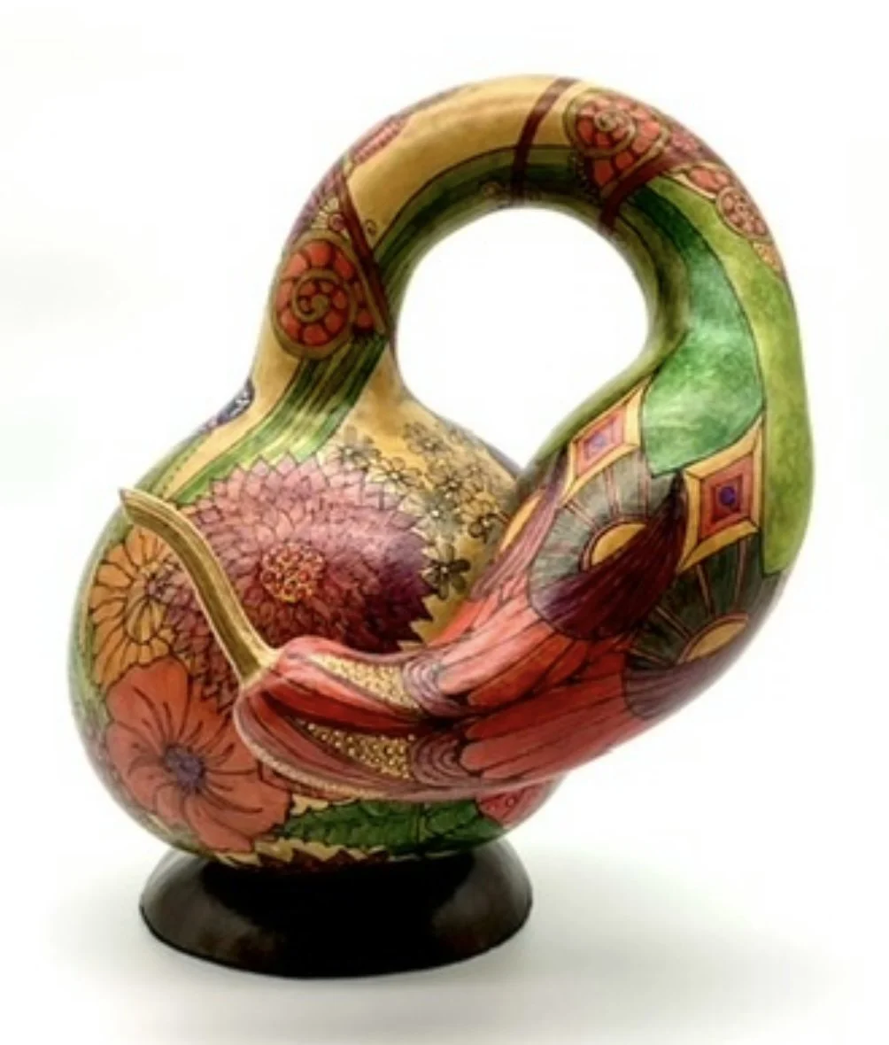 Colorful, abstract ceramic vase with floral and geometric patterns on a black base.