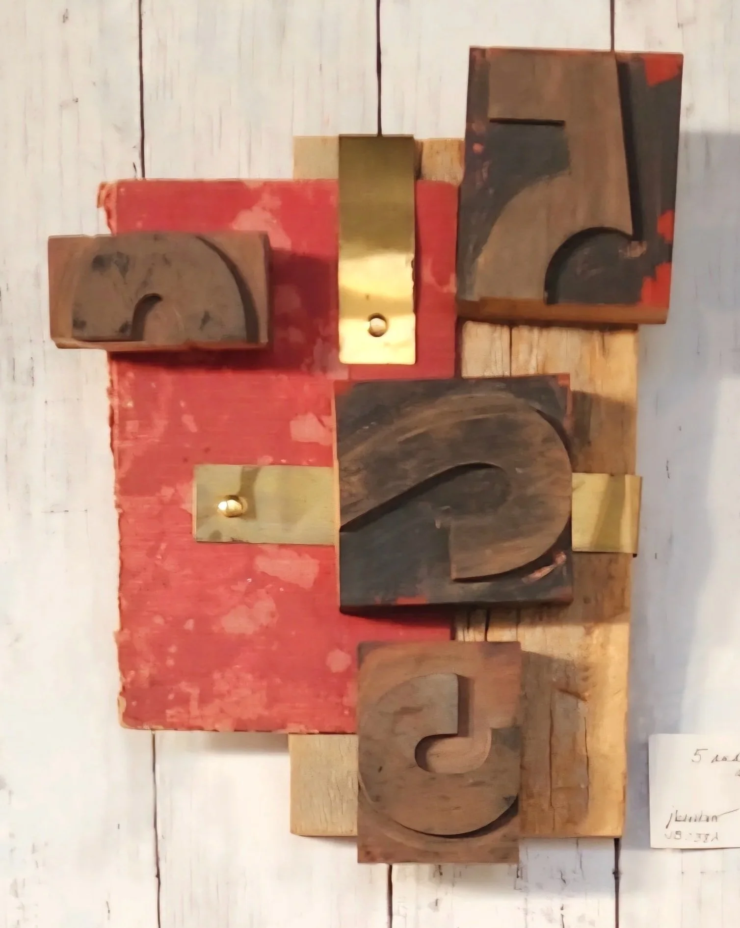 Wooden blocks with letters arranged to spell 'LOVE,' with some blocks painted red and gold accents, on a light wooden background.
