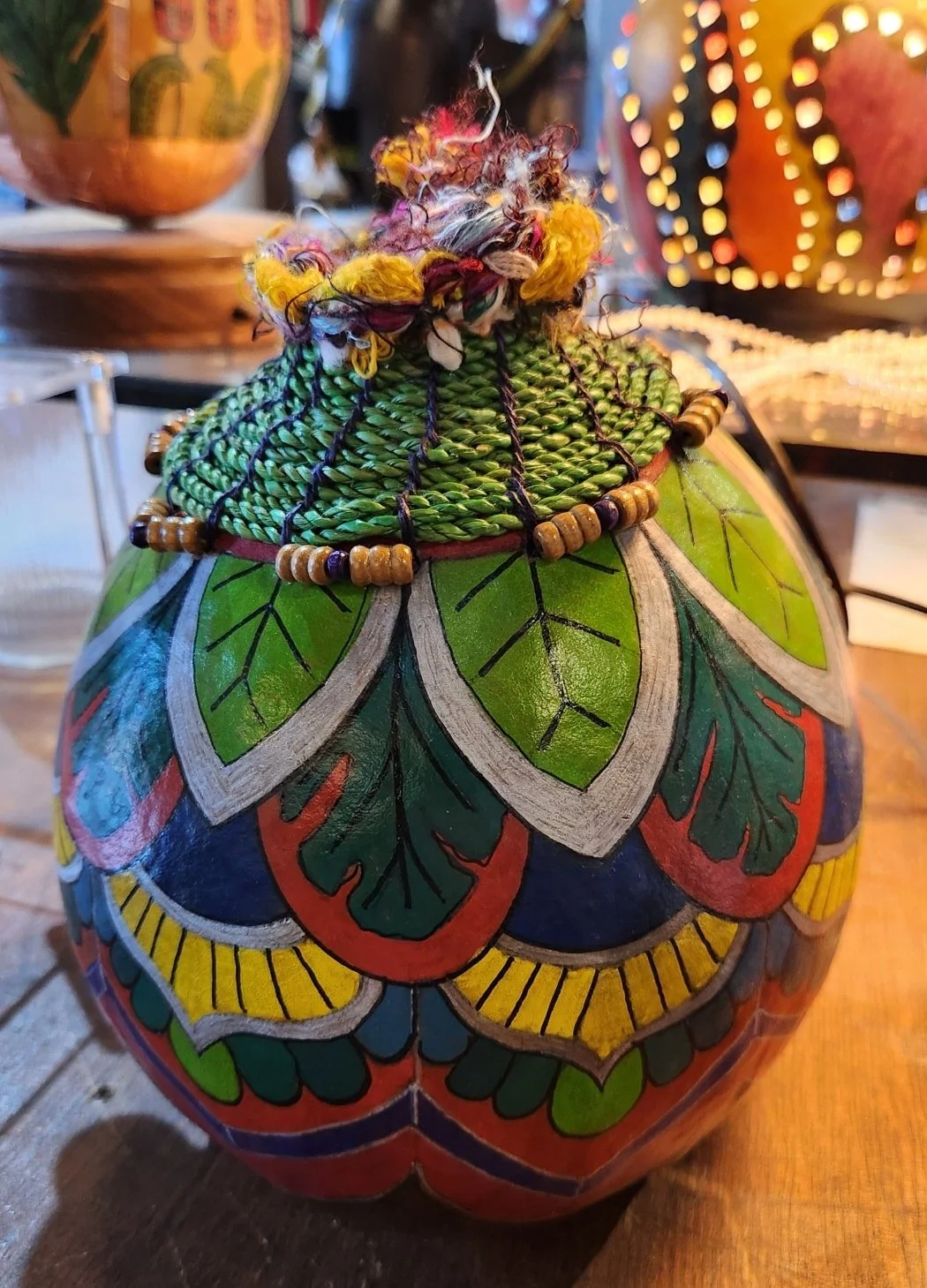 Decorative painted and beaded gourd with intricate colorful floral and leaf patterns