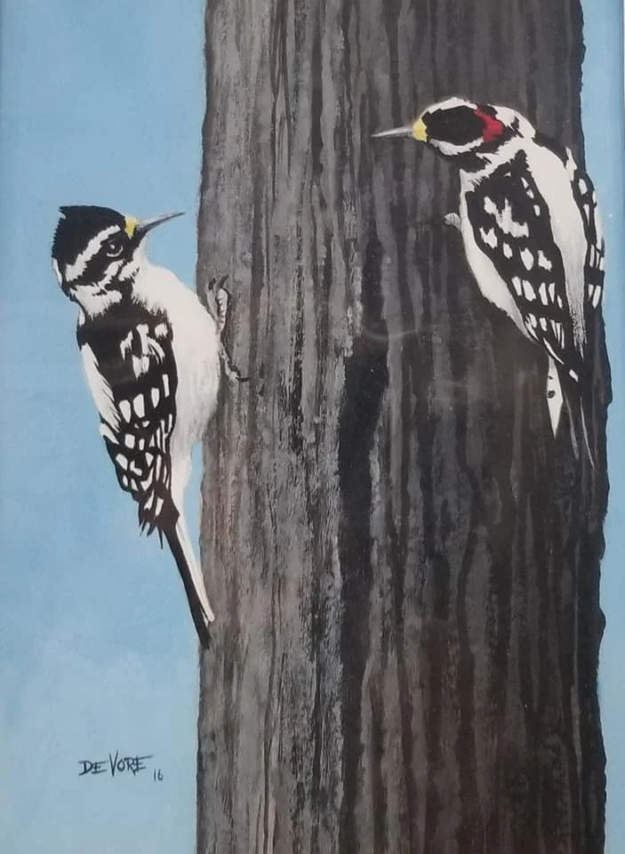 Painting of two woodpeckers on a tree trunk, one on the left and one on the right, with a blue background.