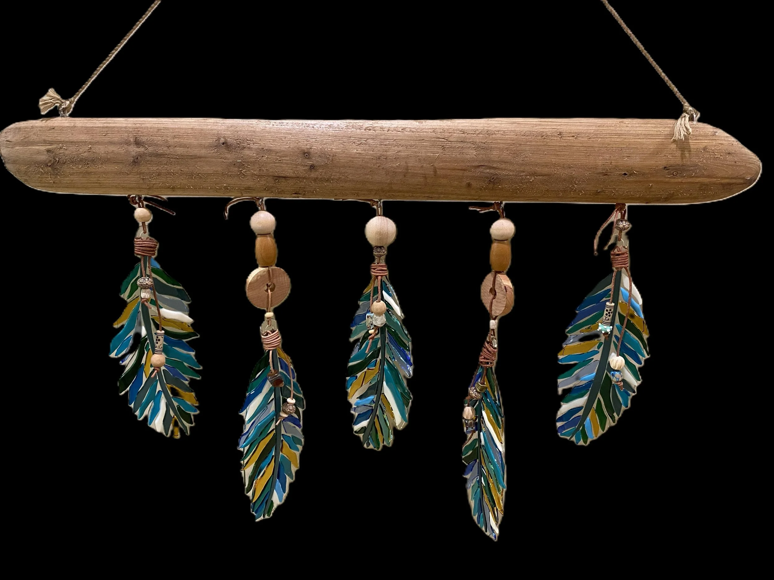 Multicolored feather and wooden bead hanging decorative piece on a wooden rod against a black background.