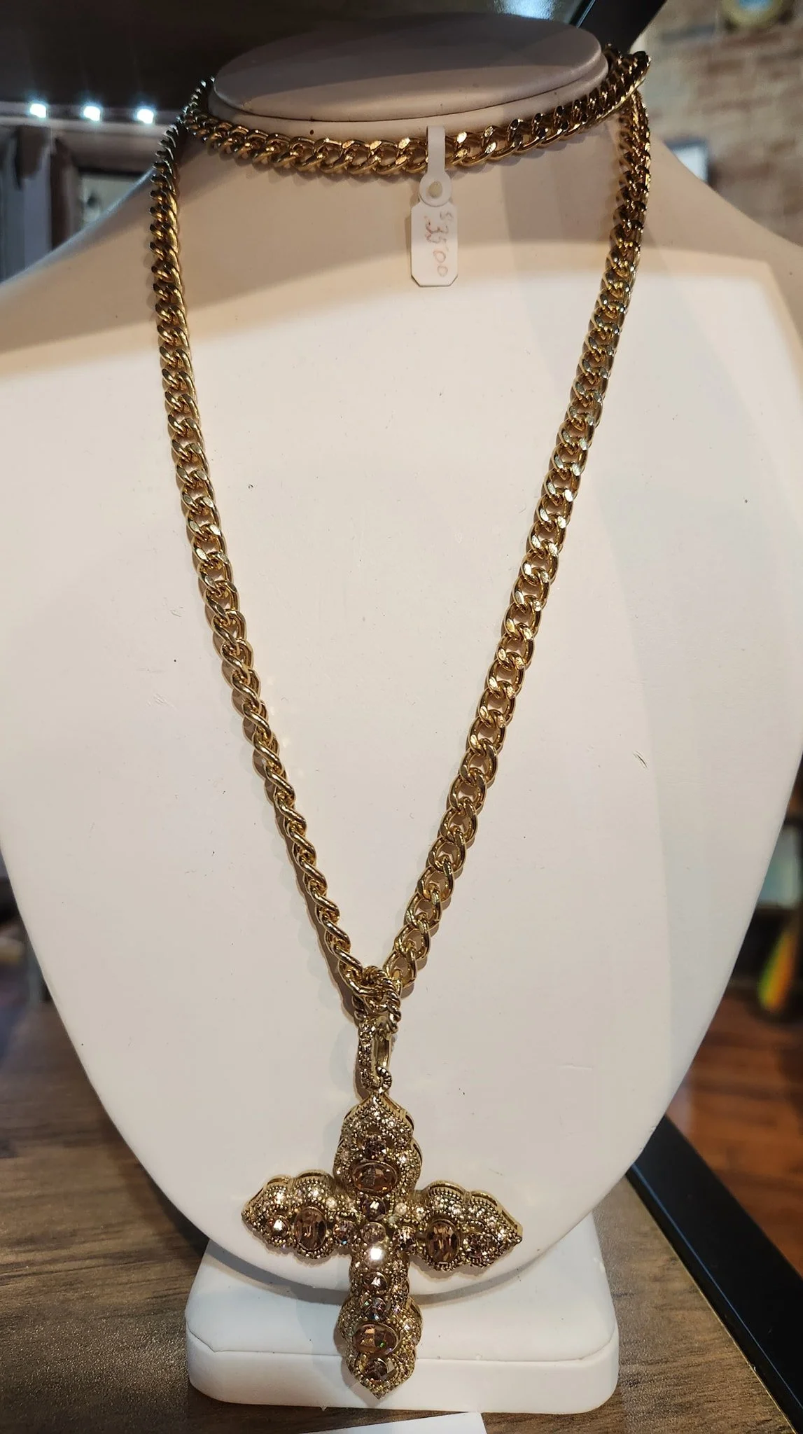 Gold chain necklace with a cross pendant decorated with rhinestones, displayed on a white jewelry bust. Price tag shows $30.00.