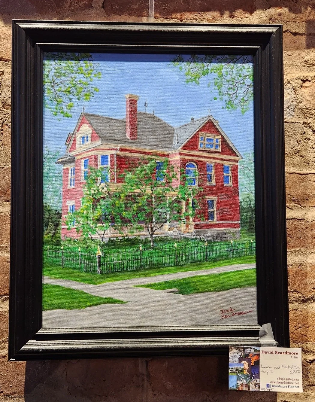 A watercolor painting of a large, red Victorian house with multiple stories, a chimney, and a front porch, surrounded by trees and a green lawn, with a brick wall in the background.
