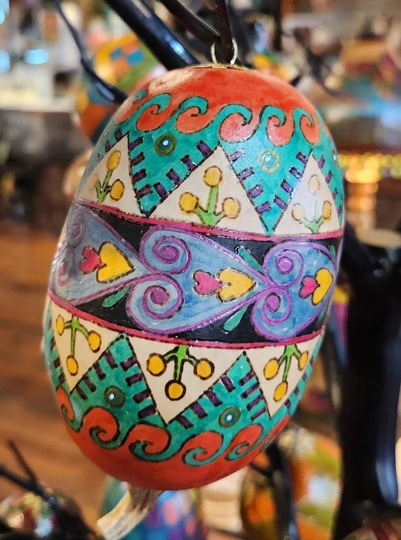 Decorative hand-painted Easter egg with colorful patterns and designs including hearts, flowers, swirls, and geometric shapes.