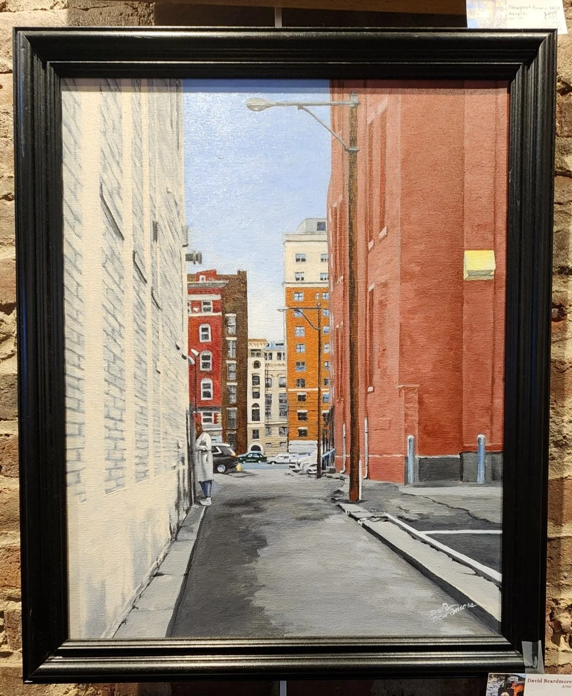 Painting of an urban alley with tall buildings on both sides, parked cars in the background, a person walking on the sidewalk, and a clear blue sky above.