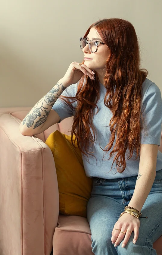 Molly Marcus, therapist & coach, with her chin on her hand, looks pensively out the window in her Philadelphia therapy office.
