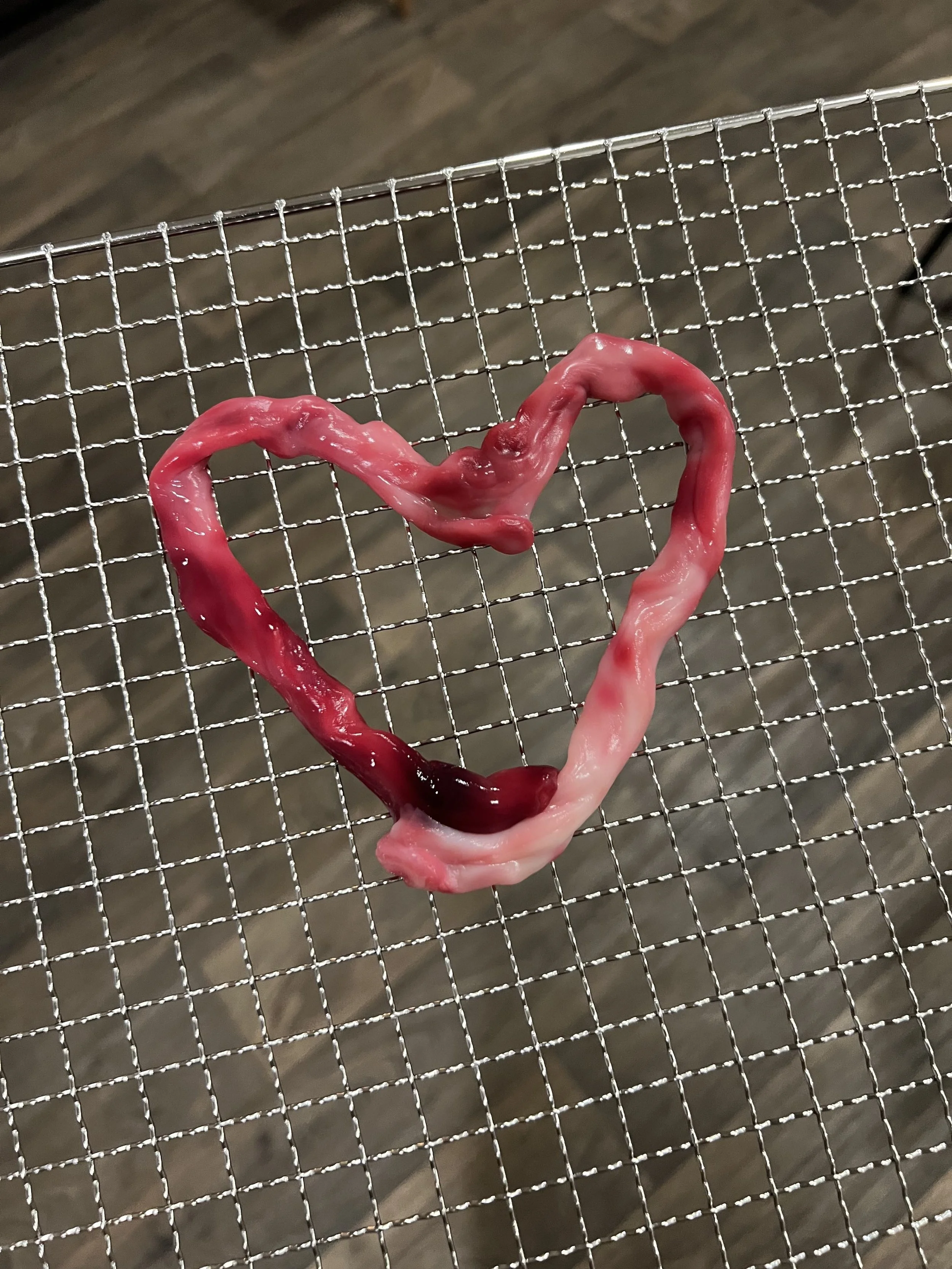 A heart shaped umbilical cord on a metal wire rack.