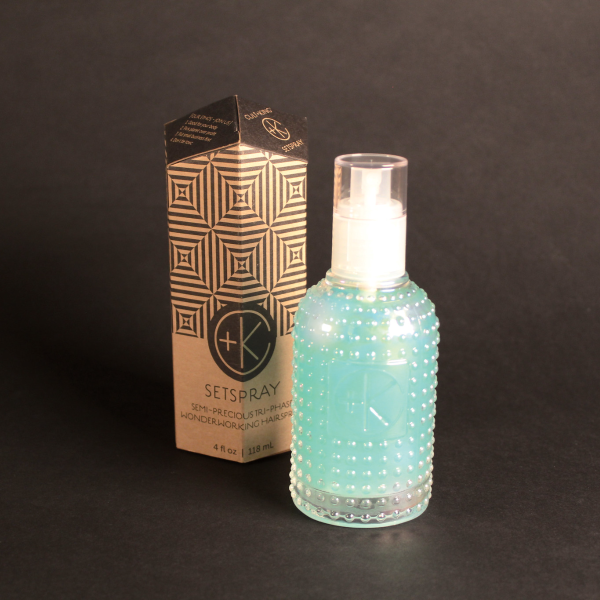 Image of set spray (blue) in a clear bottle and the box it comes in.