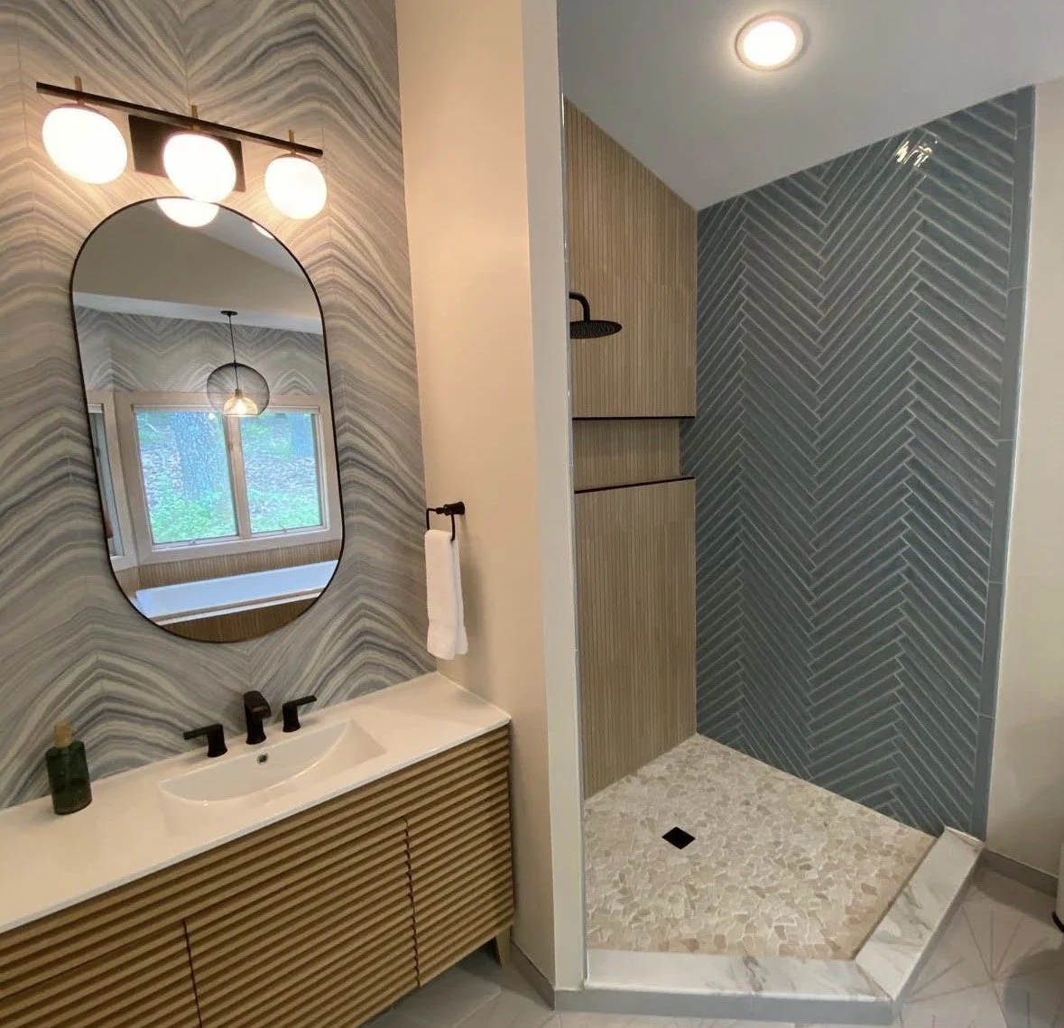 Master bathroom update-Walk-in Shower.
New walk-in shower featuring wood-look tile, herringbone detail, custom glass enclosure, and sleek black fixtures. 