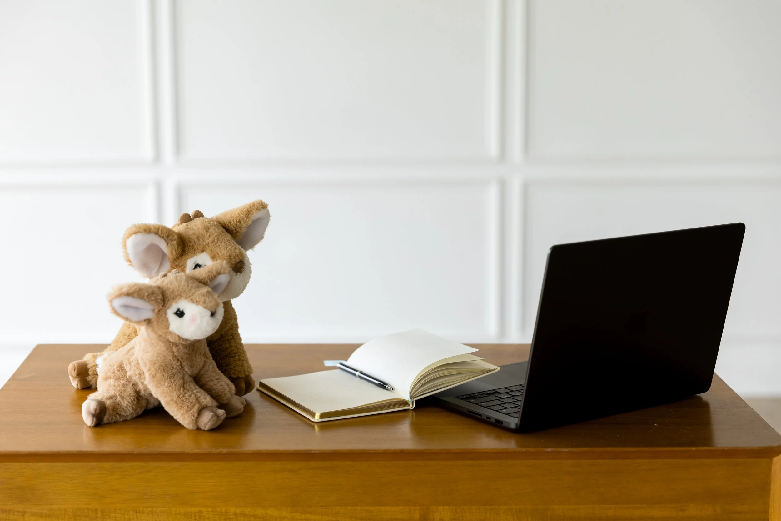 Plush reindeer, reminiscent of the main characters from When Reindeer Appear: Jingle's Story, on a writing desk