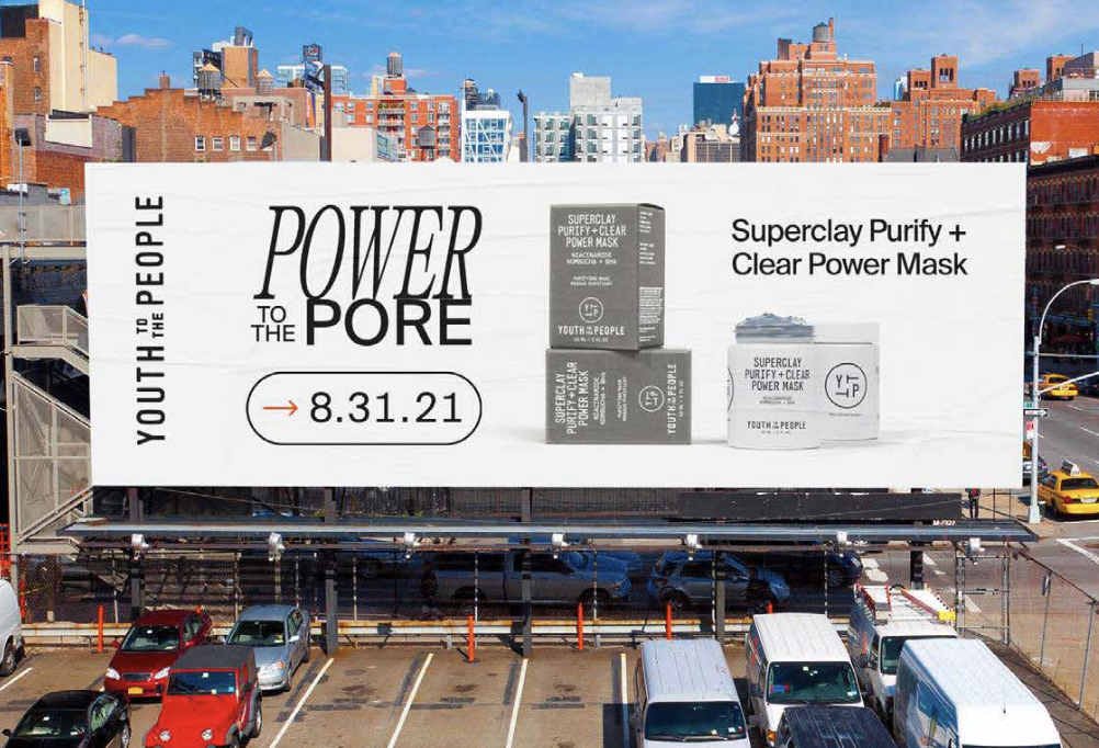 Billboard advertising Youth to the People Superfood Purify + Clear Power Mask with the date 8.31.21, set against an urban cityscape with parked cars and buildings.