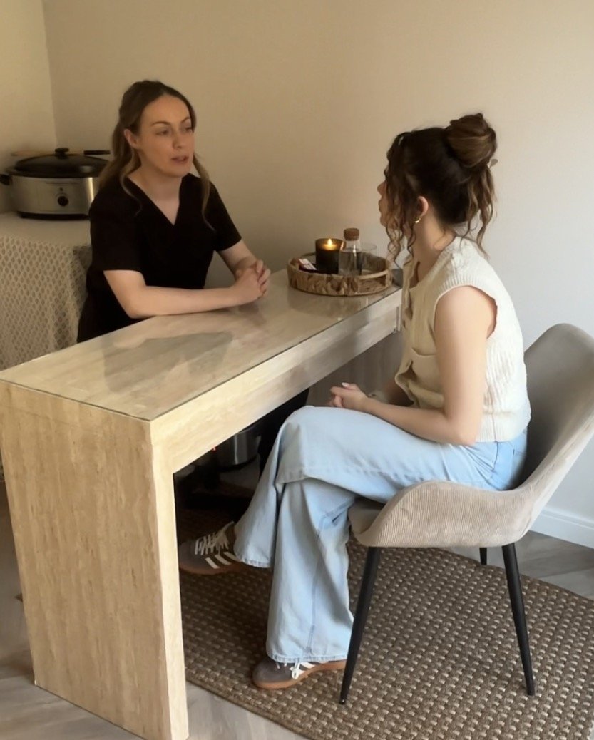 Two women sitting and talking during a skin consultaion