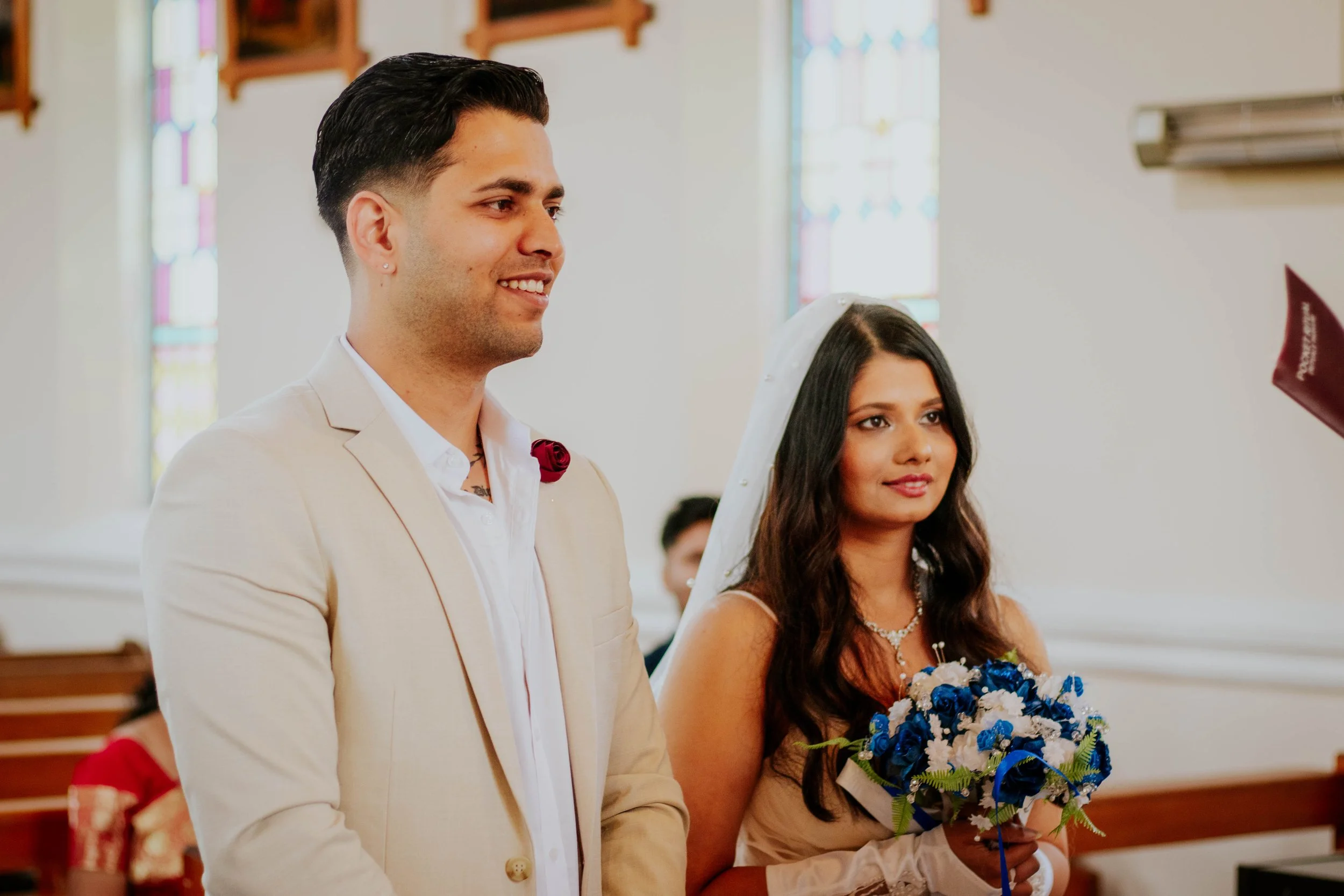 A bride and groom standing in a church during their wedding ceremony.